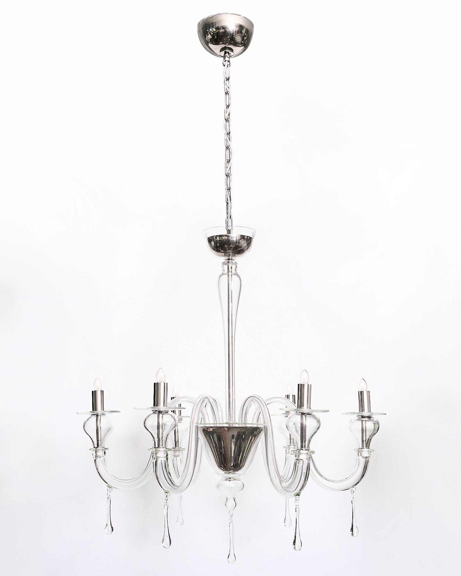 Elegant “Cristallo Puro” chandelier made of hand-blown Murano glass. It has six branches with pendants, blown bobêches. The cups and candelabras are chromed; giving this chandelier a more modern look, while the graceful movement on the branches