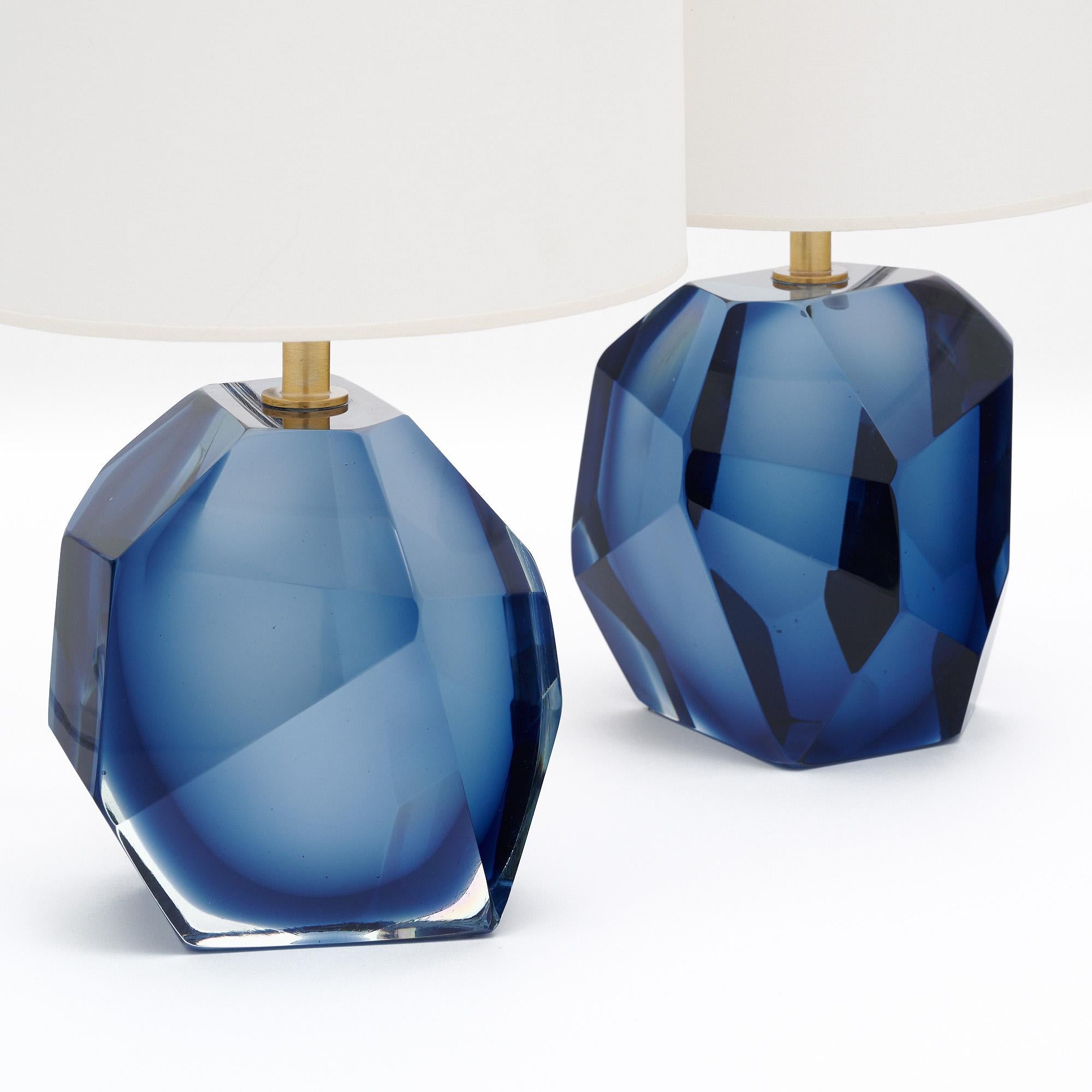 Murano glass rock lamps signed by glass maestro Alberto Dona. The hand-blown and molded glass are in the faceted shapes of crystal rocks. Brass hardware holds the shades in place. The color of the glass is a lovely and unique denim blue hue. The