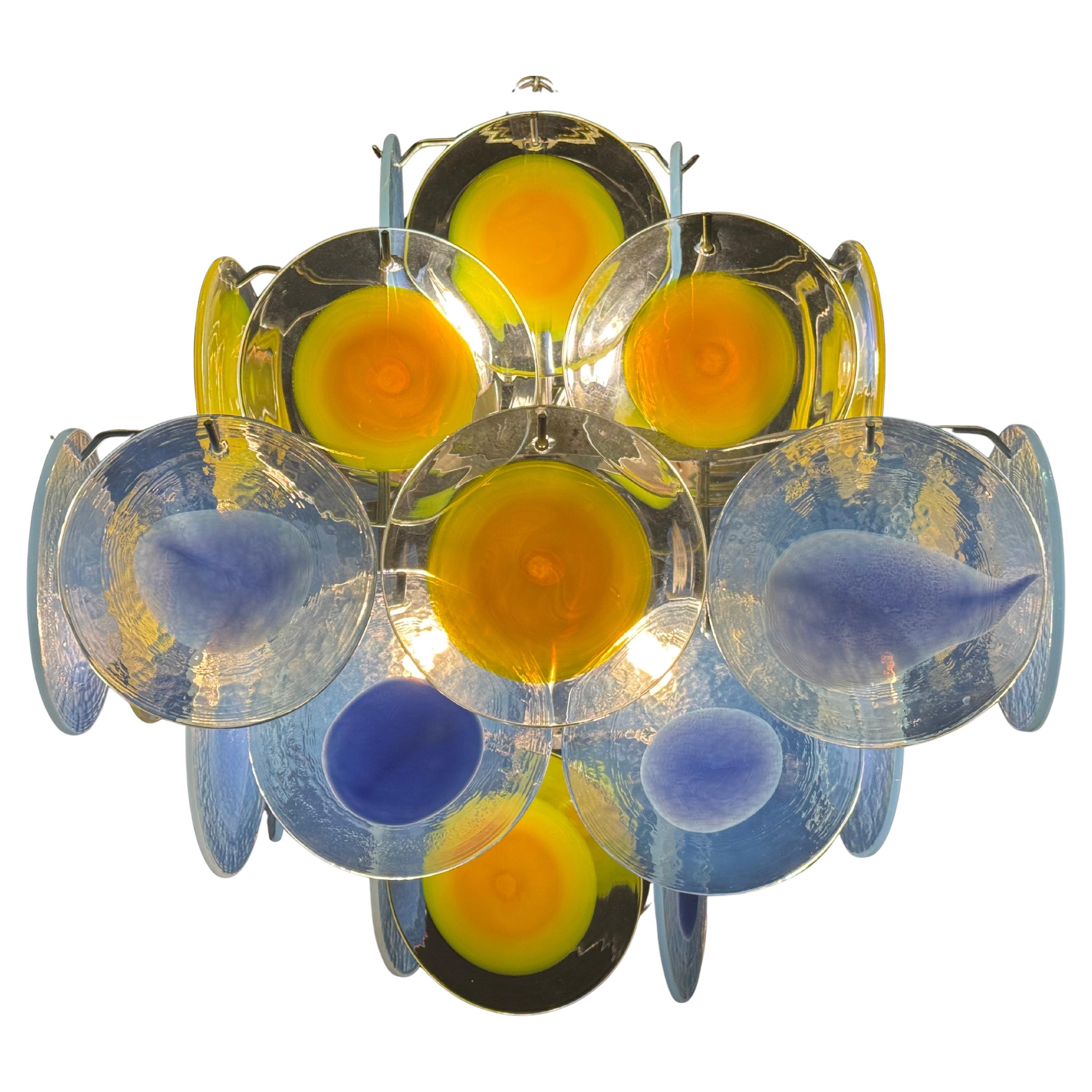Murano disc glass by Vistosi, Italy, circa 1960s
This fixture is made of blue and yellow 36 Murano glass elements hanging on the nickeled frame.
Socket: 4 x e14 for standard screw bulbs.

 