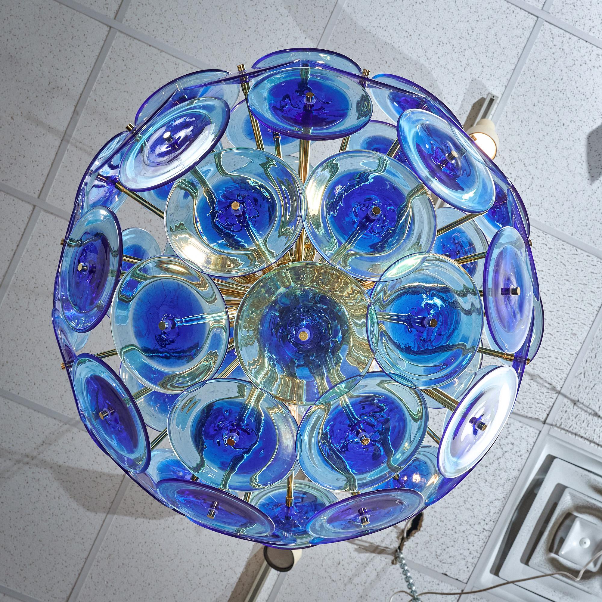 Lampadario in vetro di Murano a forma di Sputnik con bellissimi dischi di vetro soffiato a mano. Realizzato da artigiani di Murano, in Italia, ogni elemento del disco di vetro ha una meravigliosa tonalità blu cobalto ed è sostenuto dalla struttura