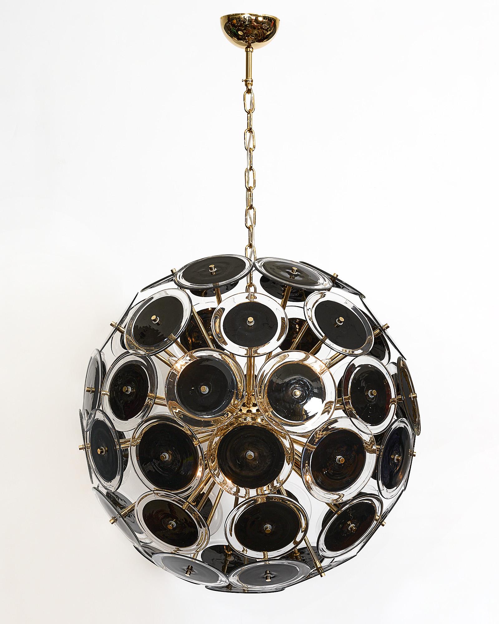 Murano glass chandelier in the sputnik shape with beautiful hand-blown glass discs. Each disc element has opaque black glass rimmed with clear glass. It has been newly wired to fit US standards.

This pair is currently a special order from our