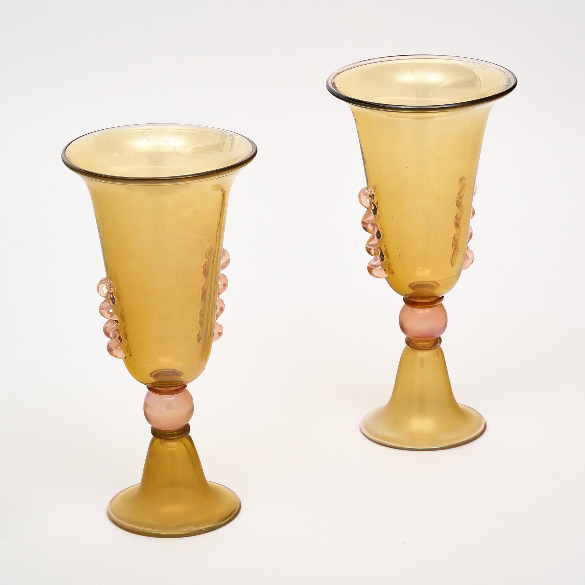 A pair of vases, Italian, from the island of Murano by Alberto Dona. This pair features classic techniques and combines pink and amber glass with a lovely iridescent hue. They are signed.