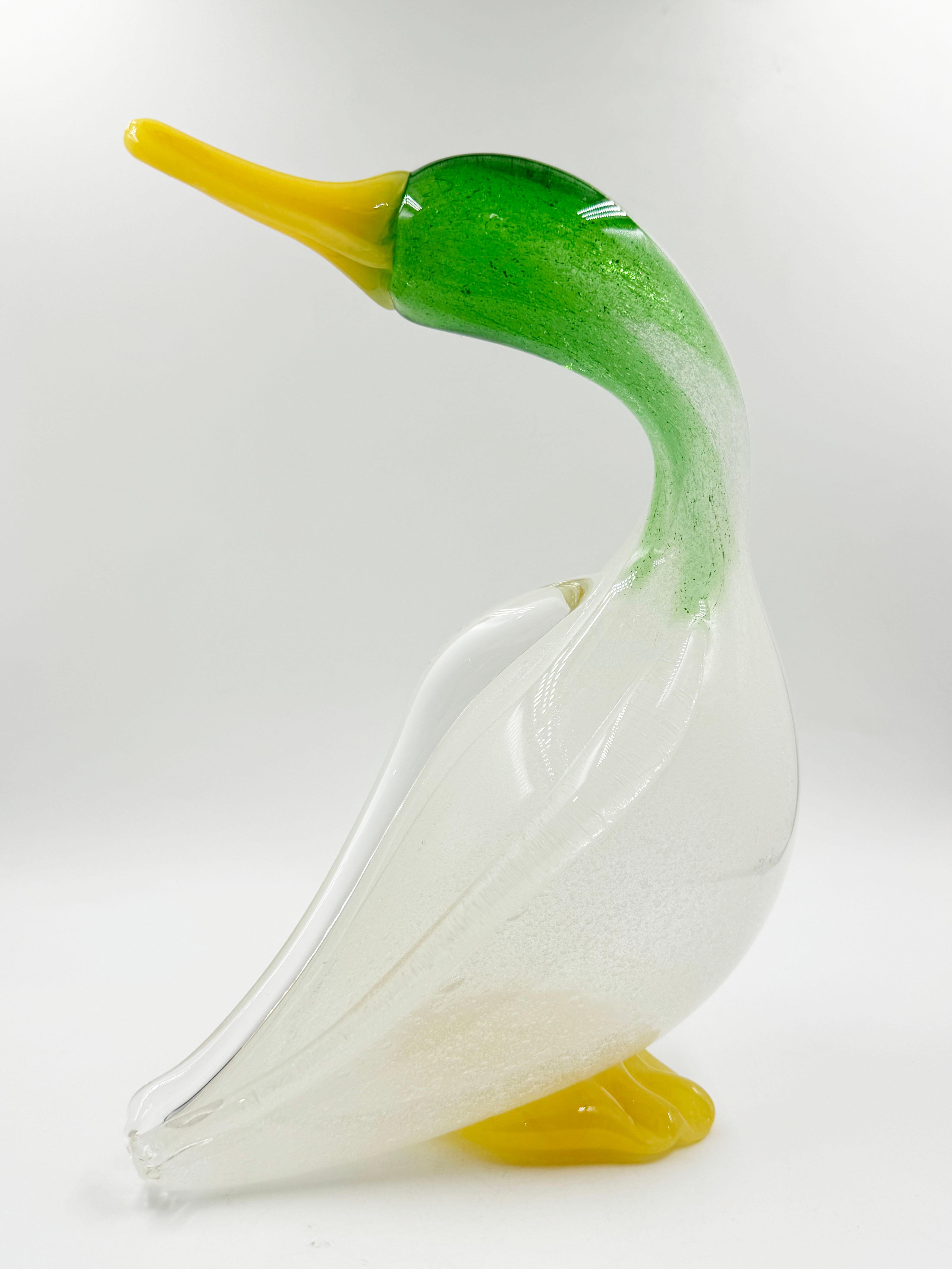 Sculpture de canard en verre soufflé vénitien
fabriquée sur l'île de Murano, vers les années 1950. 
La tête verte entre les pieds et la bouche le rend différent et charmant.
Une belle œuvre d'art pour n'importe quelle pièce.

Mesures :
Profondeur