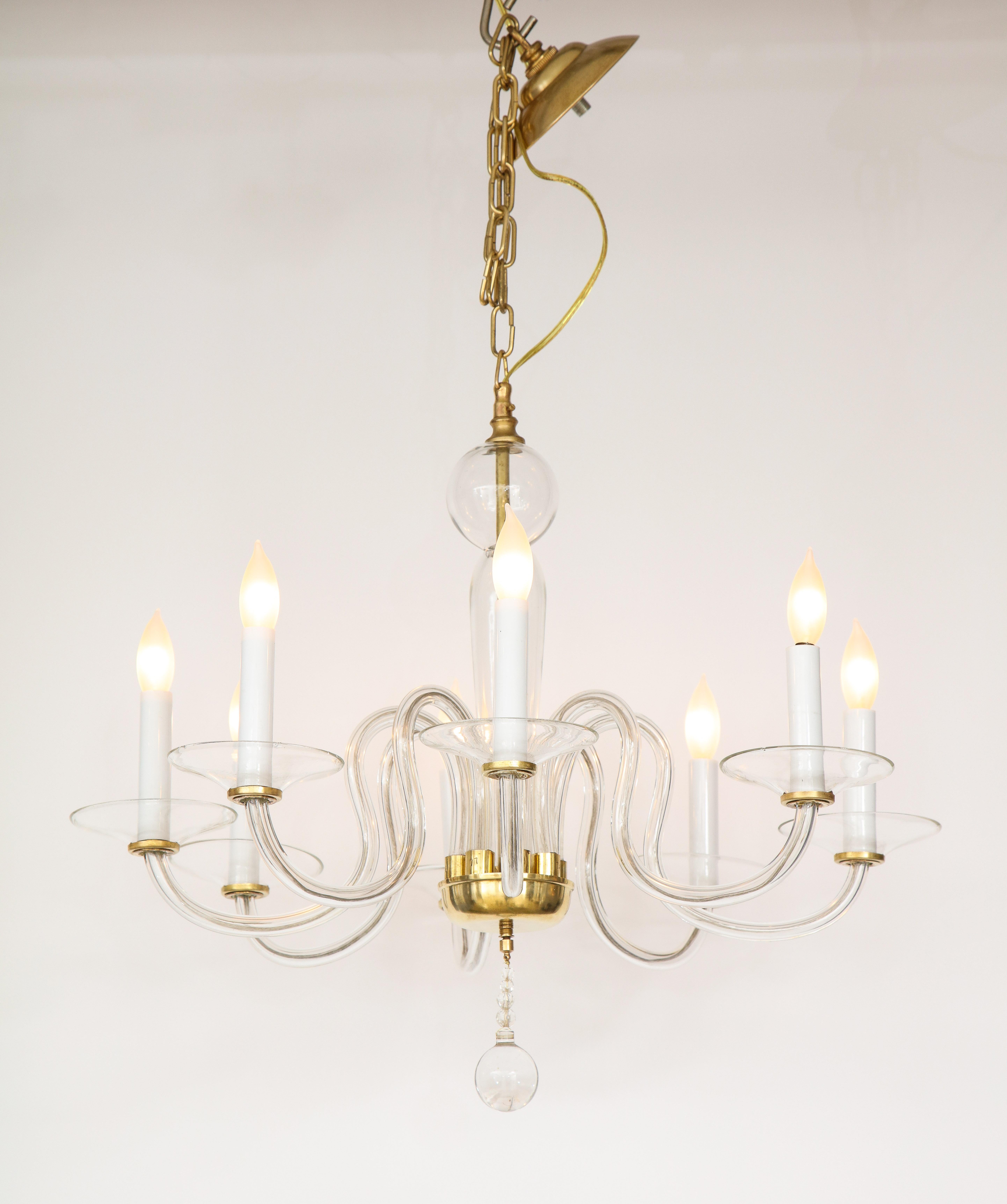 A Murano Mid-Century Modern hand blown glass chandelier with eight arms with brass supported bobeche, stem and base canopy with a graduated glass ball finials. The eight arms are elegantly curved and evoke a sleek modernist aesthetic. Re-wired for