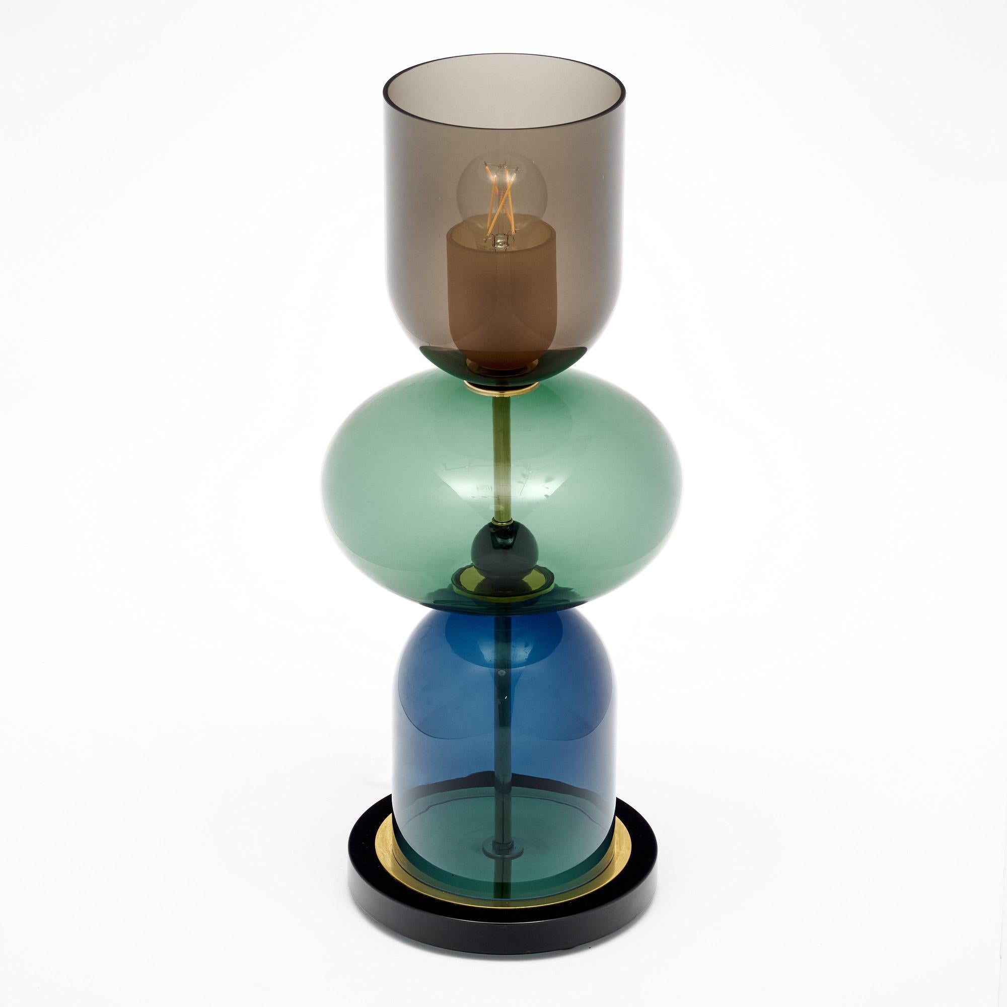 Coppia di lampade da tavolo realizzate con elementi in vetro soffiato a mano provenienti da Murano, in Italia, alle porte di Venezia. Ogni lampada è caratterizzata da componenti di vetro unici nei toni del fumo, del verde e del blu su una struttura