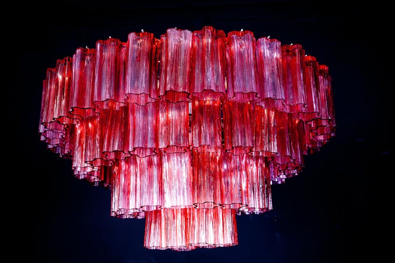 Fabulous chandelier with rare stunning fire red color precious Murano glasses.
Each chandelier with 80 glass blown elements supported by a chrome frame. Light off the glasses are fuschia red. With a light on the color of the glasses turn in a magic