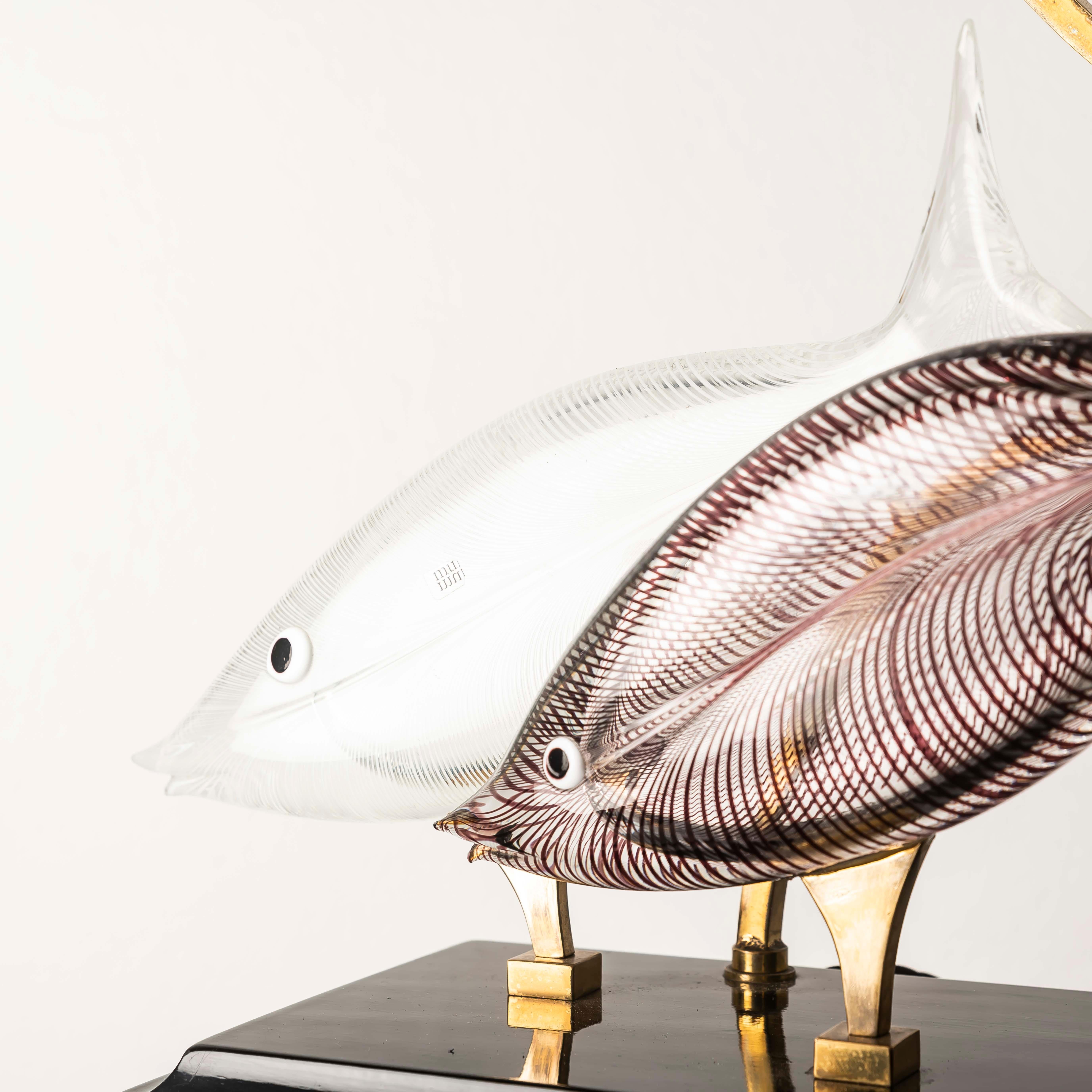 Une étonnante lampe de table sculpturale attribuée au célèbre maître verrier de Murano, Licio Zanetti, fabriquée en Italie dans les années 1970. Cette pièce unique présente deux poissons en verre de Murano soufflé à la main - l'un en cristal clair