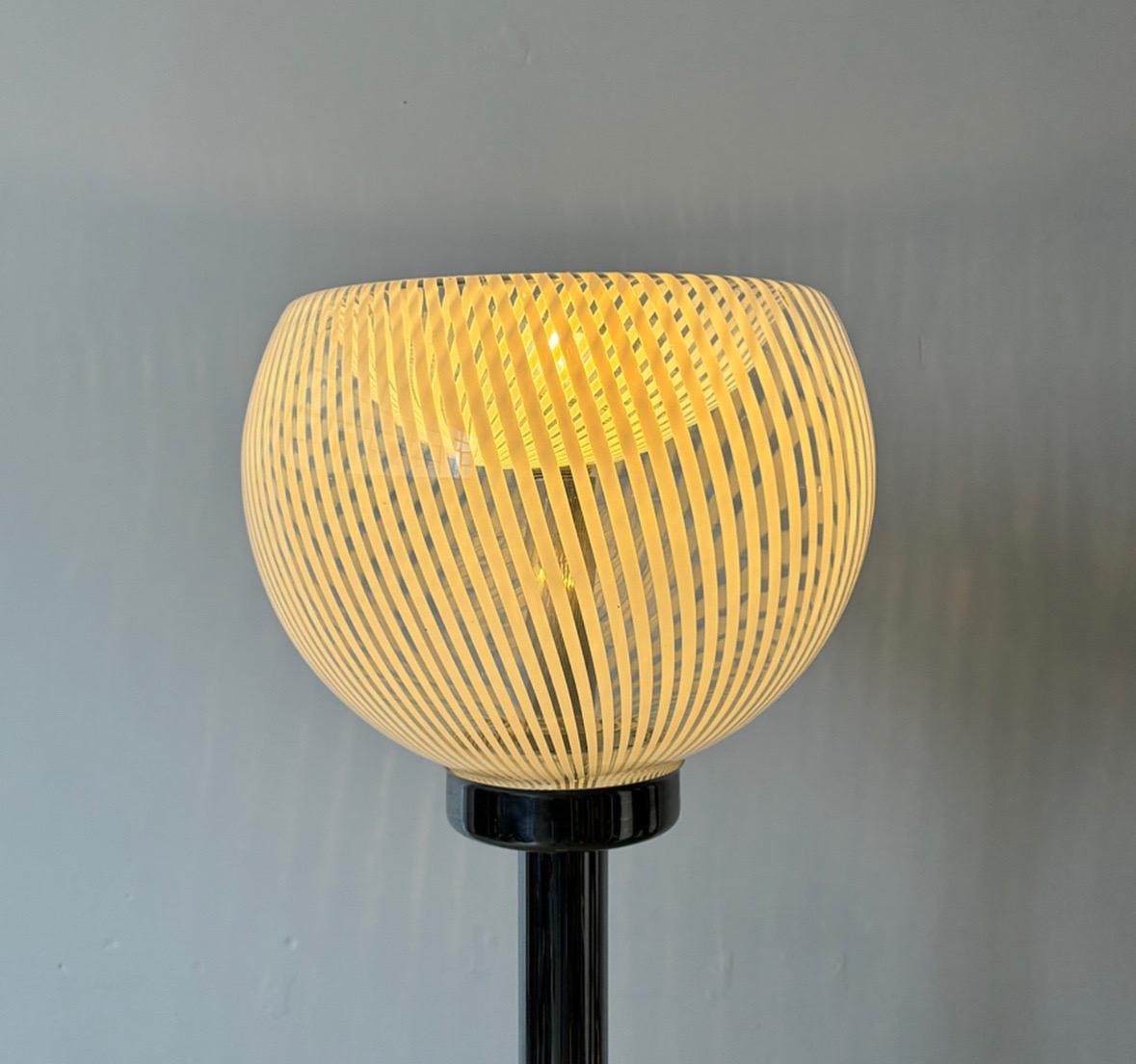This floor lamp from the 1970s, crafted by Venini, features a sleek chrome metal stem and a captivating Murano glass lampshade. This piece exemplifies the harmonious blend of minimalist design with artistic flair that defines midcentury modern