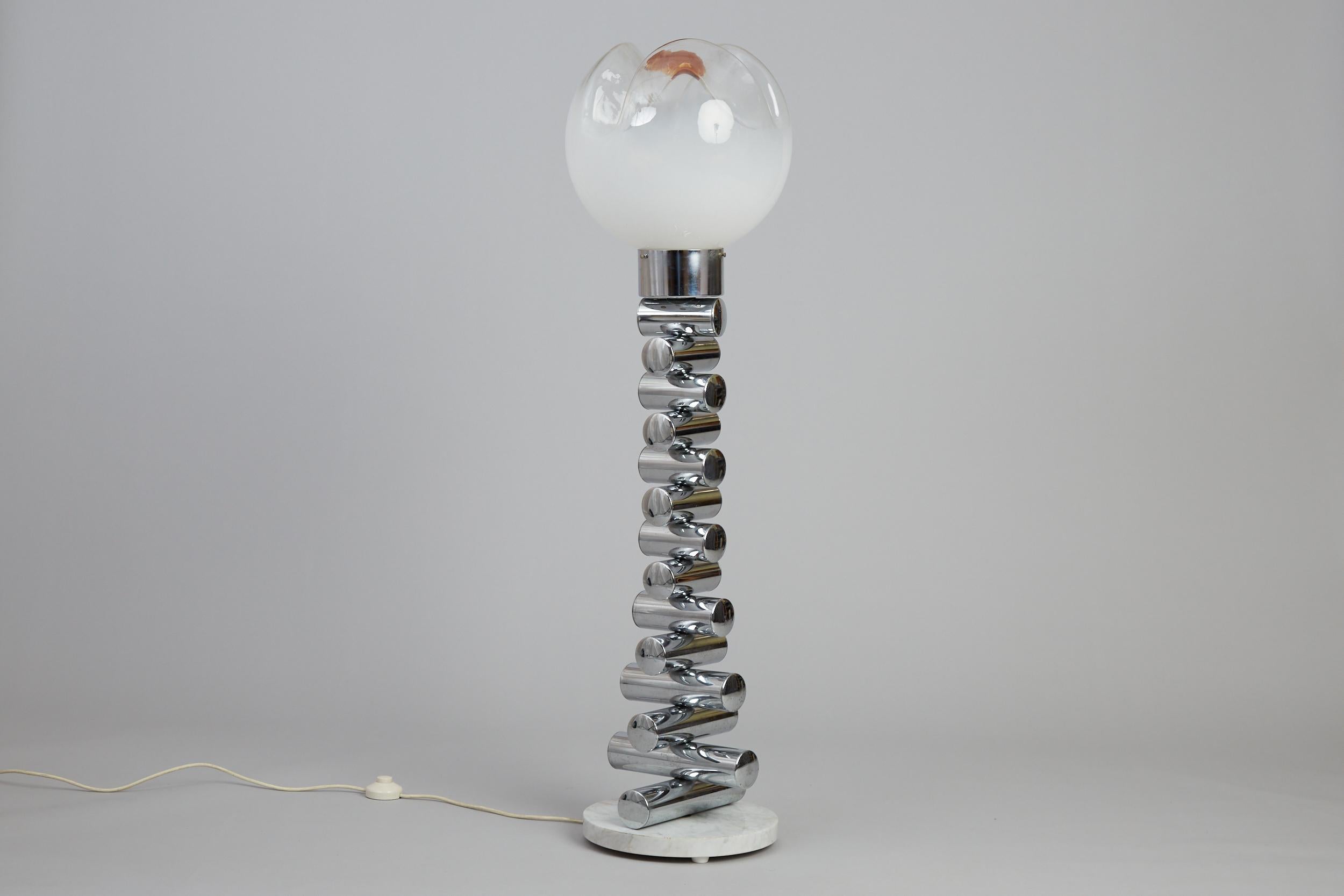 Lámpara de pie italiana del siglo XX diseñada por Carlo Nason para Mazzega.

Compuesta por una llamativa pantalla floral de cristal de Murano sobre tubos de acero inoxidable apilados, montada sobre una base de mármol blanco.

Italia, hacia la década