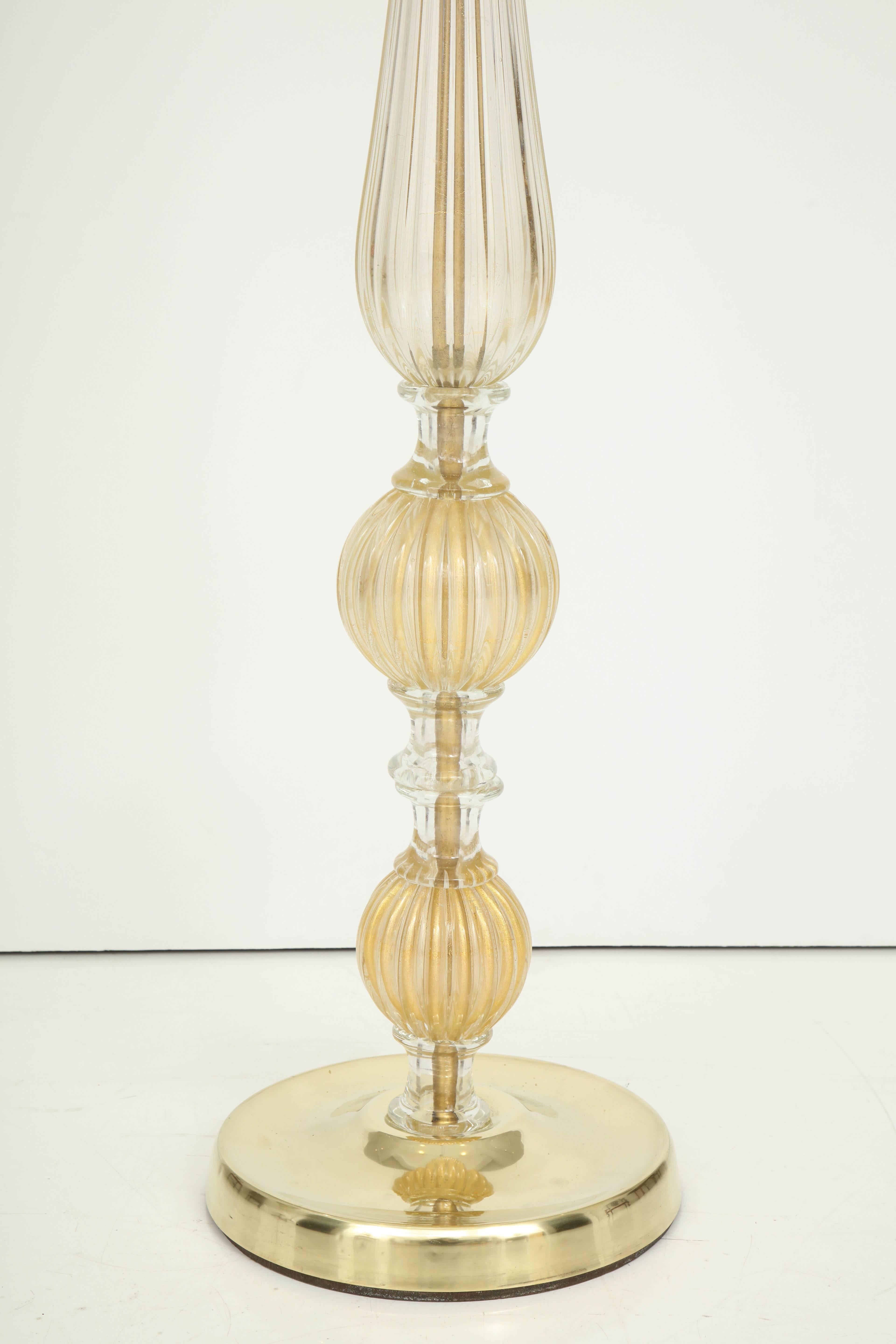 A magnificent floor lamp in Murano glass with gold leaf inclusions. The exquisite detail, including the fluted glass, the clear glass connectors and the brass base, give this lamp a sculptural quality. It not only provides light, but is a work of