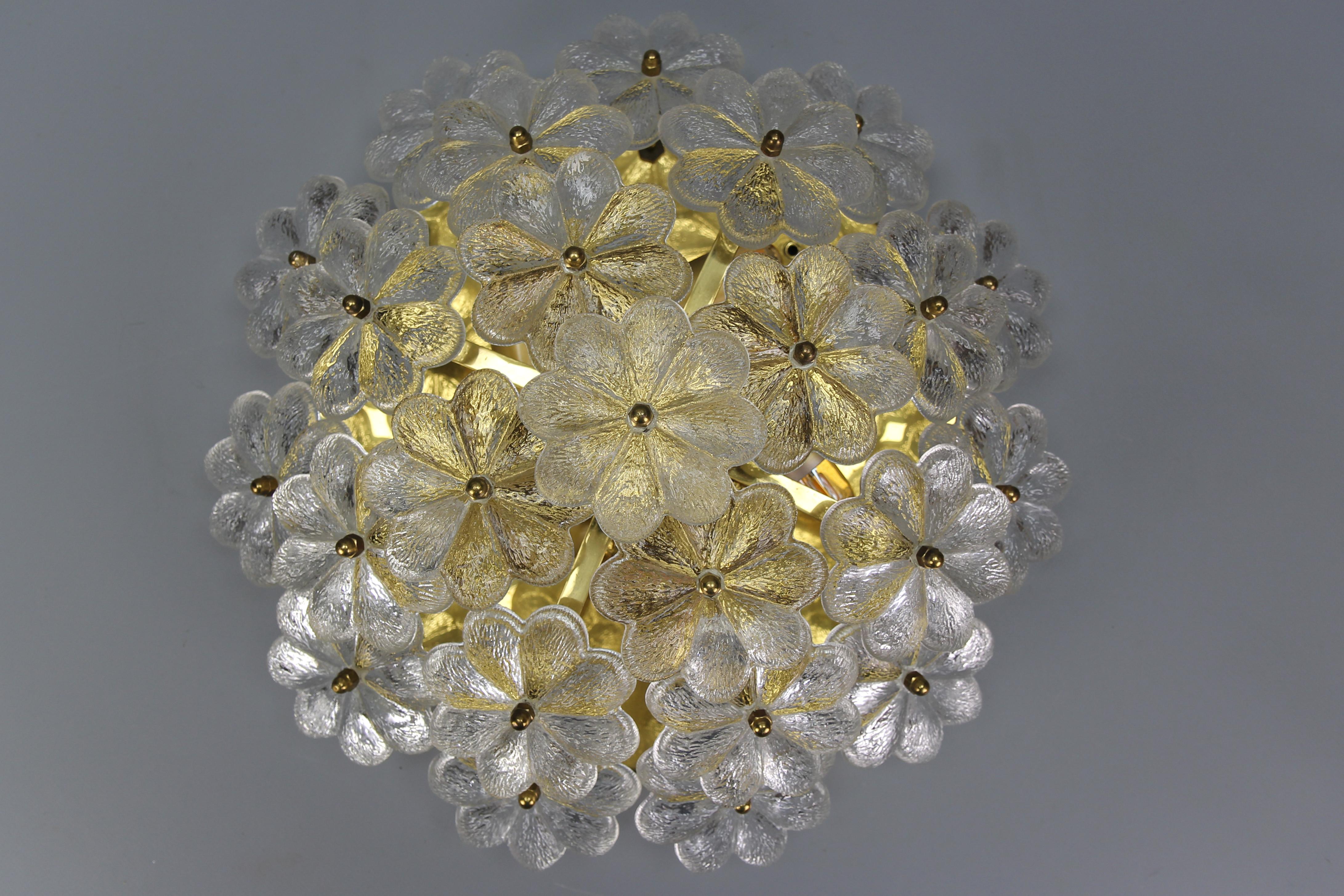 Murano glass flower and brass flush mount by Ernst Palme, Germany, 1970s.
This beautiful Mid-Century Modern period flush mount by Ernst Palme features a brass frame and 24 thick clear Murano glass flowers. The light fixture can be used as a wall