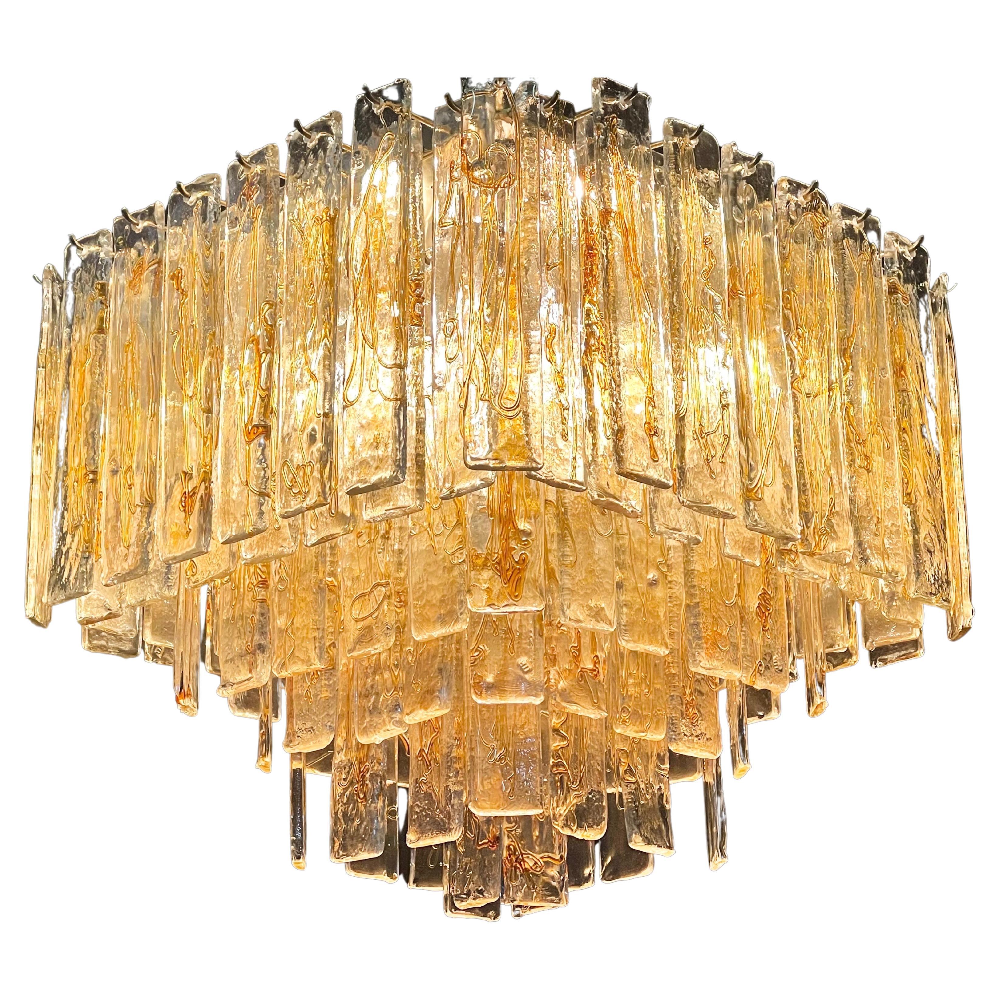 Rare encastré en verre de Murano de style nouille ambrée, datant du milieu du siècle, par Venini ou Mazzega, Italie, vers les années 1960.
Le lustre est composé de plus de 100 éléments en verre Murano Mazzega et d'une armature en métal