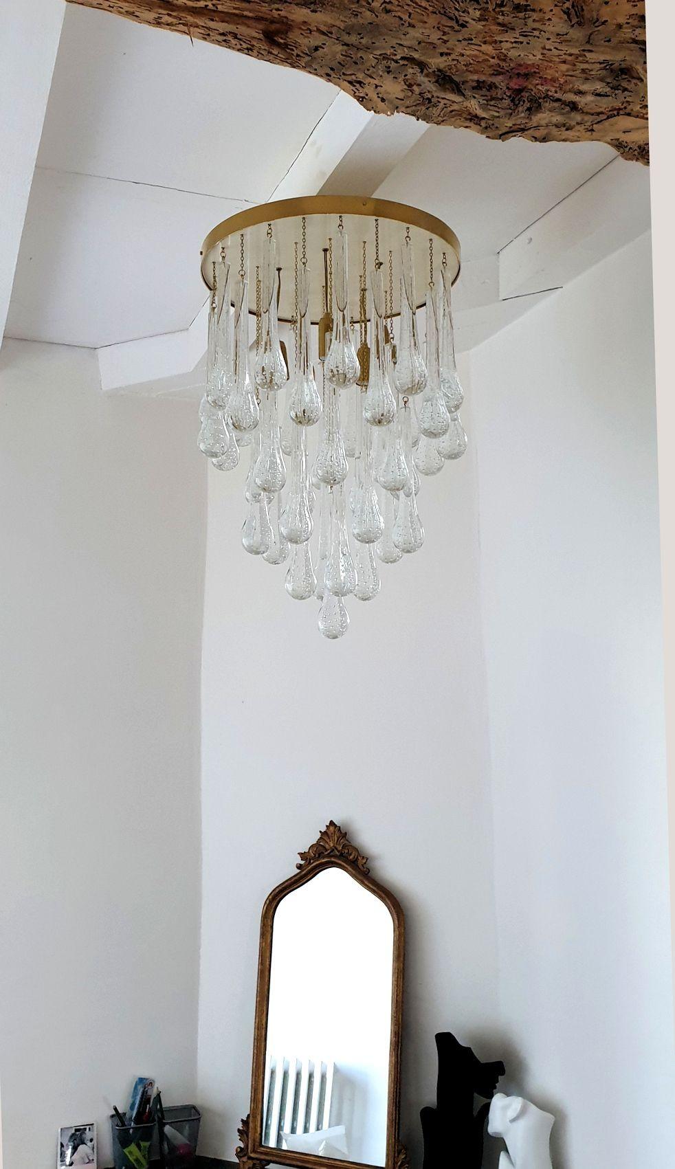 Lámpara de cristal de Murano de mediados de siglo, con forma de lágrima, Italia, años 80. A la manera de Venini.
El empotrable vintage está formado por una placa de techo redonda de latón y marfil, y gotas de cristal transparente de Murano en