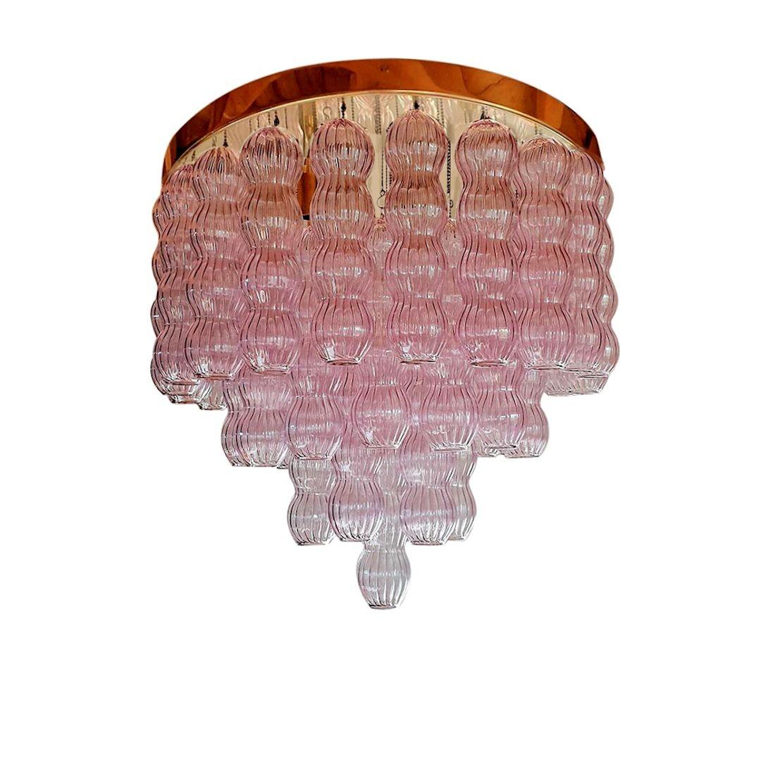 Large Murano glass Mid-Century Modern flush-mount chandelier by Mazzega, Italy 1970s.
The Italian flush-mount is made of a polished round brass ceiling plate and
Light purple Murano glasses; each glass hanging with a beaded brass chain to the