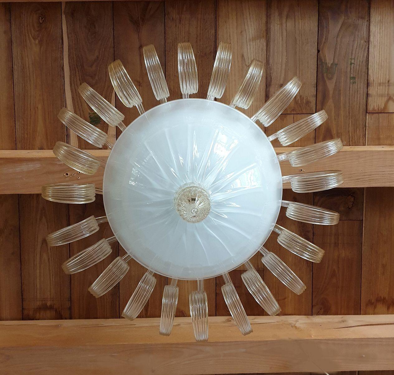 Neoclassical style hand blown Murano glass flush mount chandelier, attributed to Venini, Italy 1970s.
This beautiful quality chandelier is made of clear with gold leaf decor twisted leaves, a white central bowl nesting the lights, with gold painted