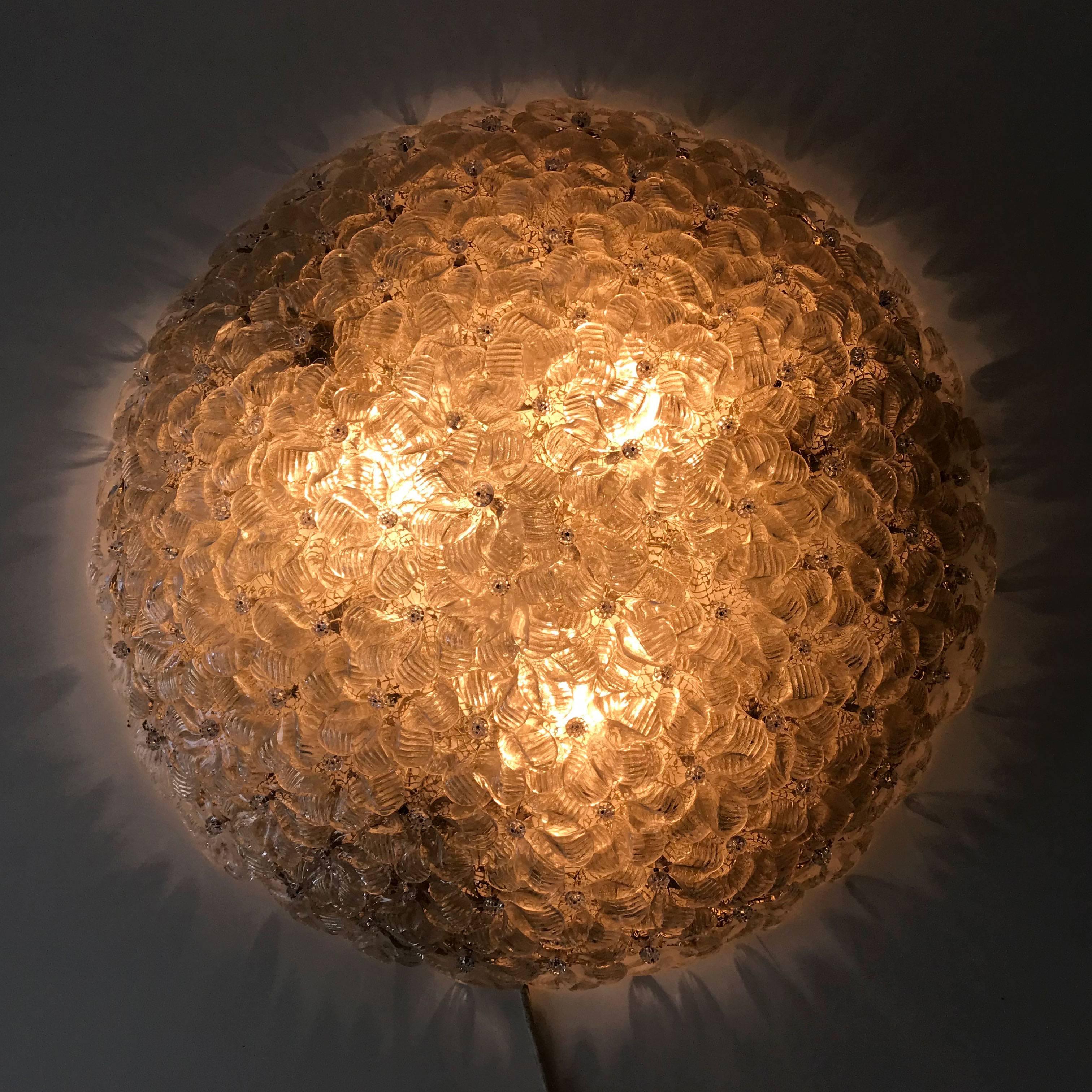 Decorative and rare Mid-Century Modern Italian flush mount ceiling fixture or wall lamp from circa 1960s. Manufactured by Barovier & Toso, Italy. The lamp consists of numerous Murano glass flowers with gold inclusions.
The lamp is executed with