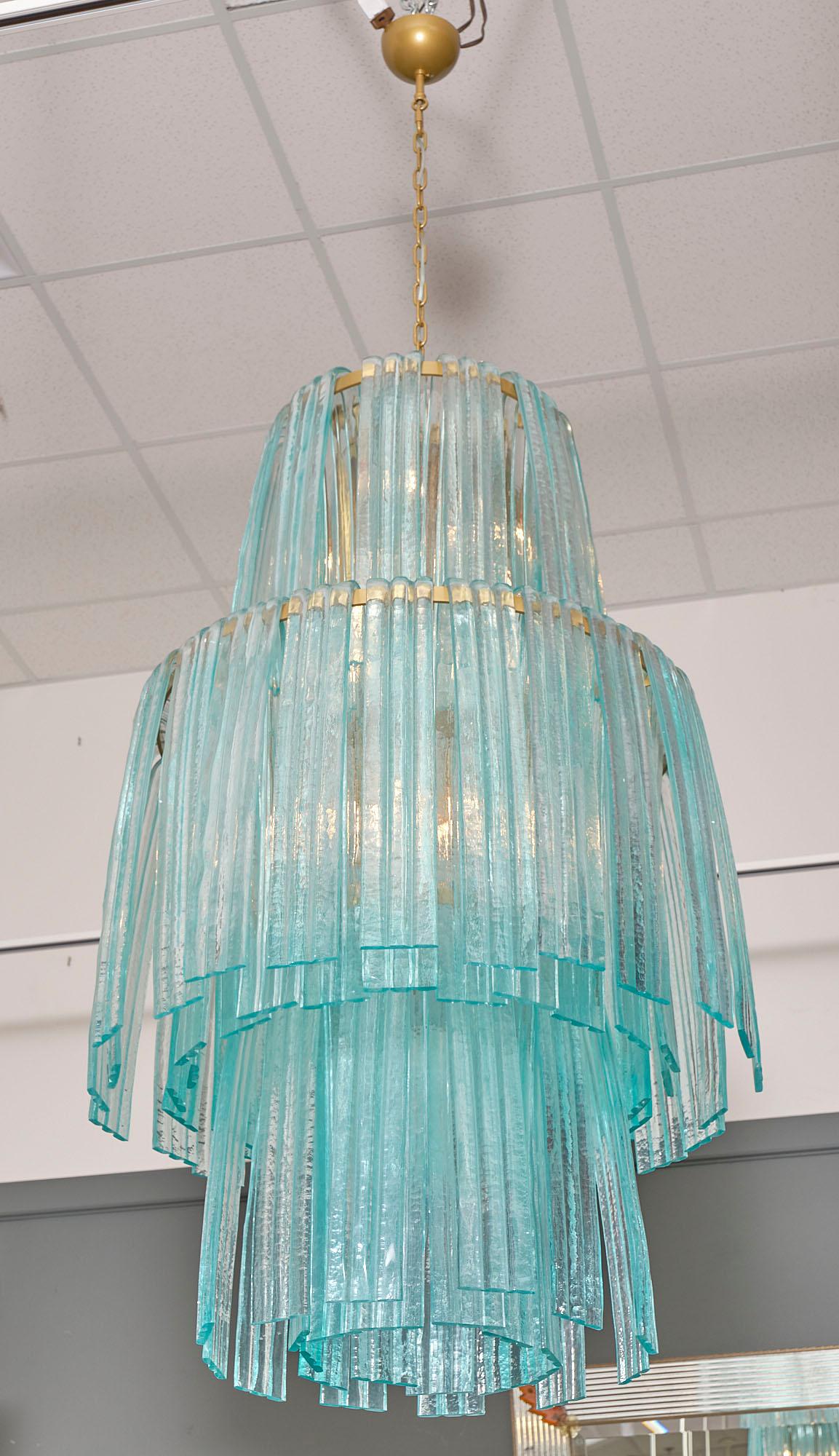 Murano glass “forcine” chandelier in an aquamarine blue. This Italian piece features hand-blown cascading glass components that are supported by a brass structure. This fixture has been newly wired to US standards.

This chandelier is currently