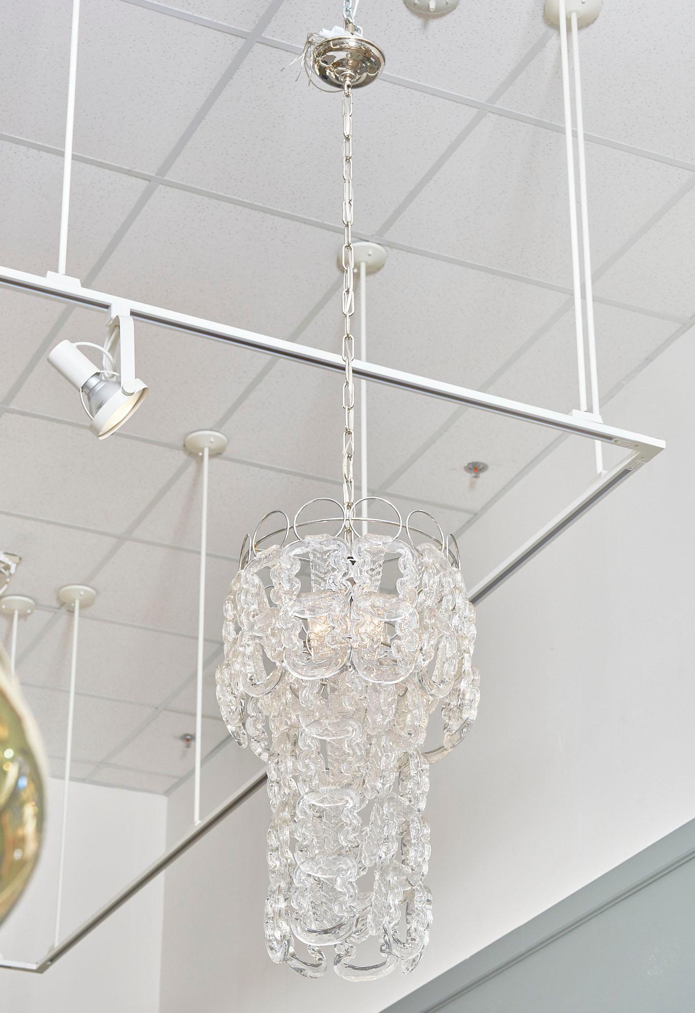 Chandelier; vintage; from Italy in the Modernist style. We love the multiple twist shaped “ganci” (hooks) hang from the original nickeled steel structure. It has been newly wired to fit US standards.

This piece currently has a height from ceiling