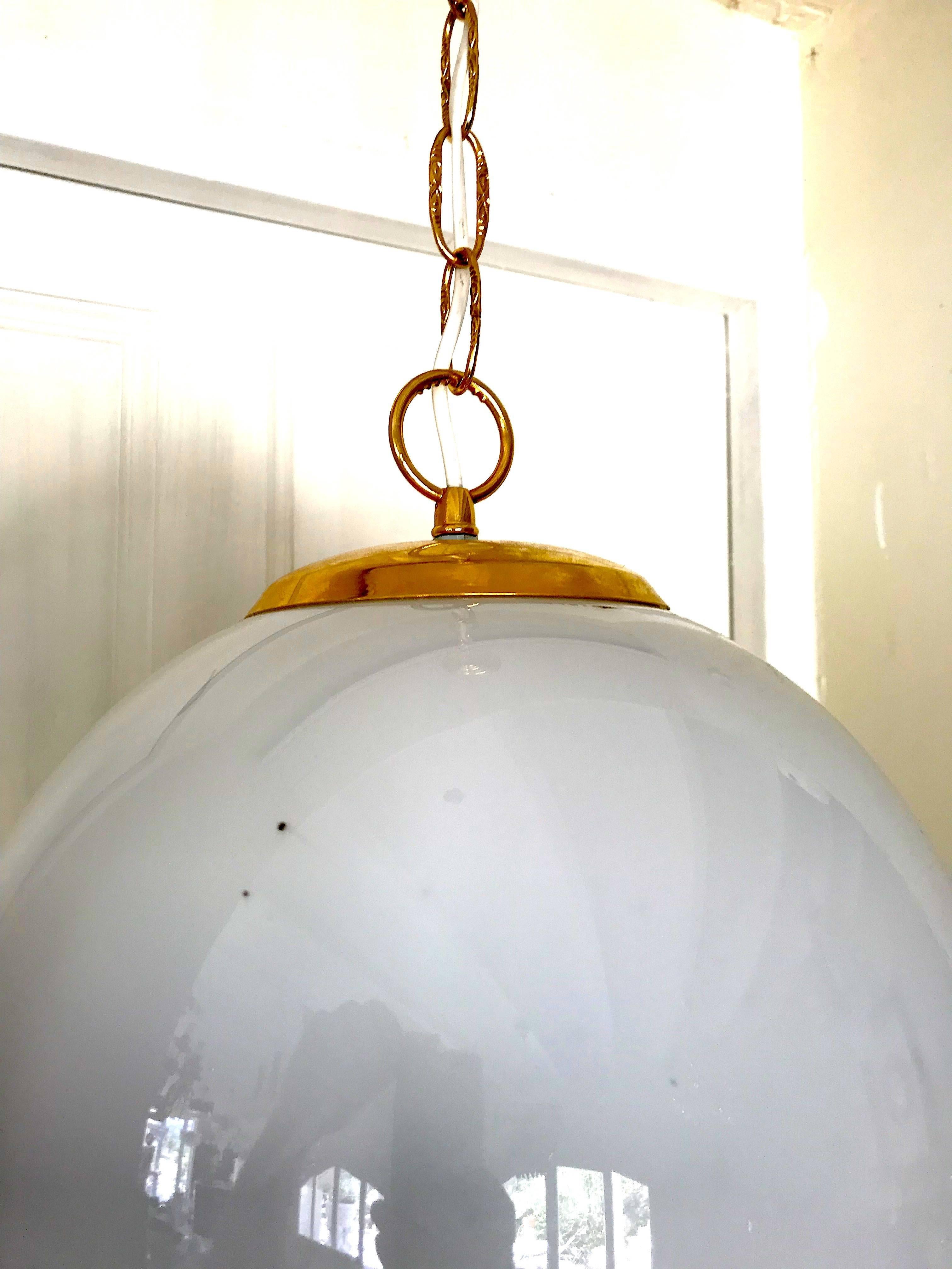 A midcentury handblown Murano globe of white glass with all-over internal bubbles with an undulating double helix of amber and black, the fixture suspended by a chrome original chain. Measures: 30 cm.
A real stunning ORIGINAL vintage period lamp !!