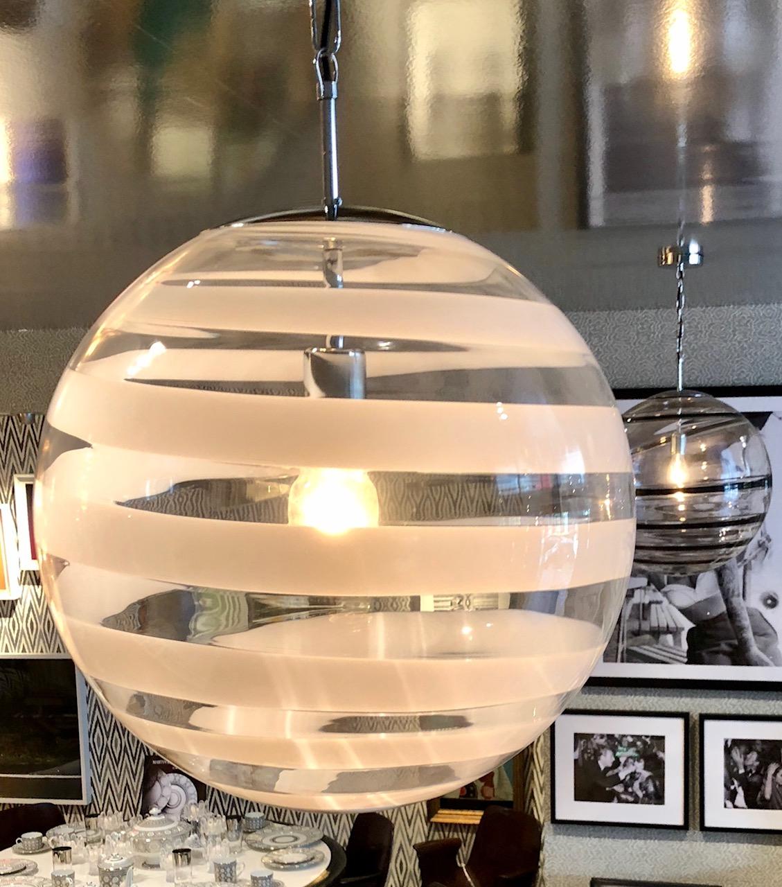 Custom hand blown Murano glass globe pendants with white swirl accent, the white swirl design differ slightly for individuality. Chrome chain and ceiling canopy.