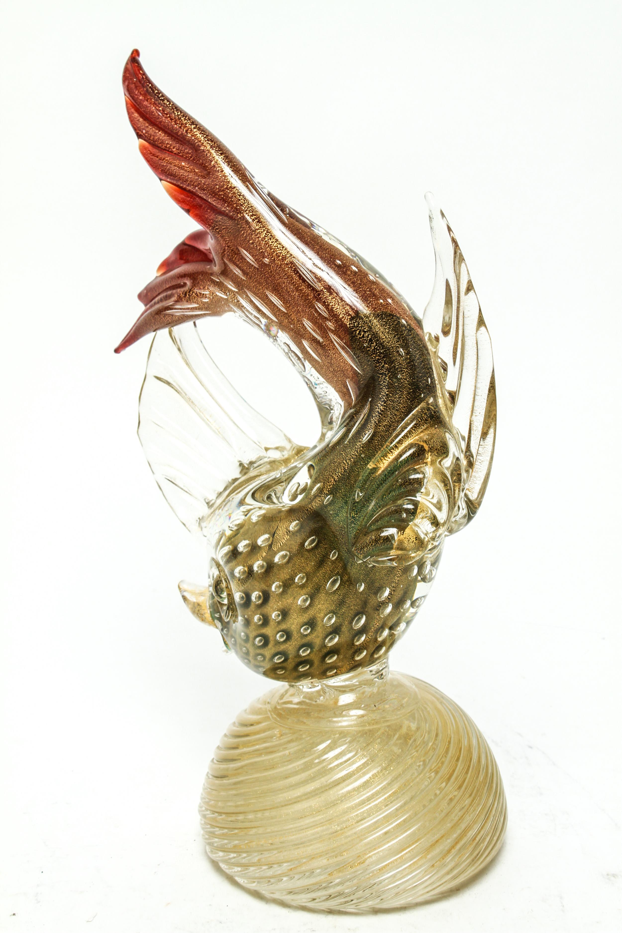 Italian Mid-Century Murano glass fish sculpture with a body made of gold flecked clear glass with controlled bubbles, fin ends in red, atop a spherical dome with spiral motif. The piece is in great vintage condition.