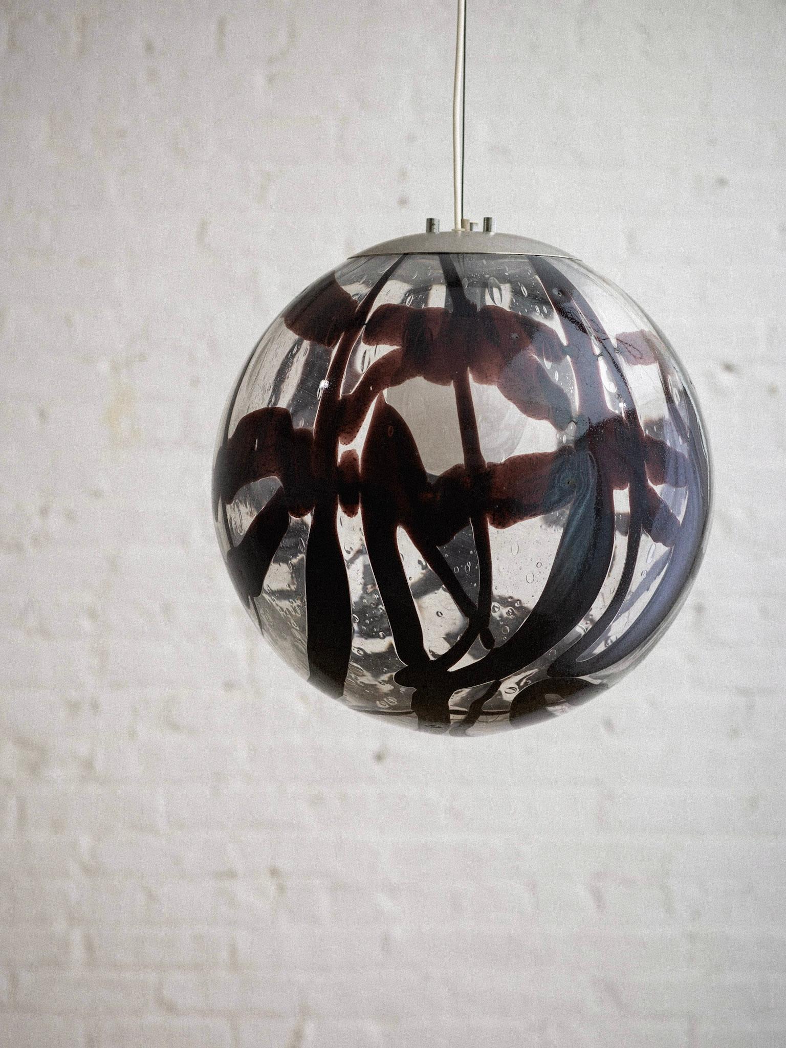 A midcentury Italian Murano glass globe pendant light. Clear glass with a dark abstract graphic pattern. Brushed chrome hardware. Sourced in Northern Italy.