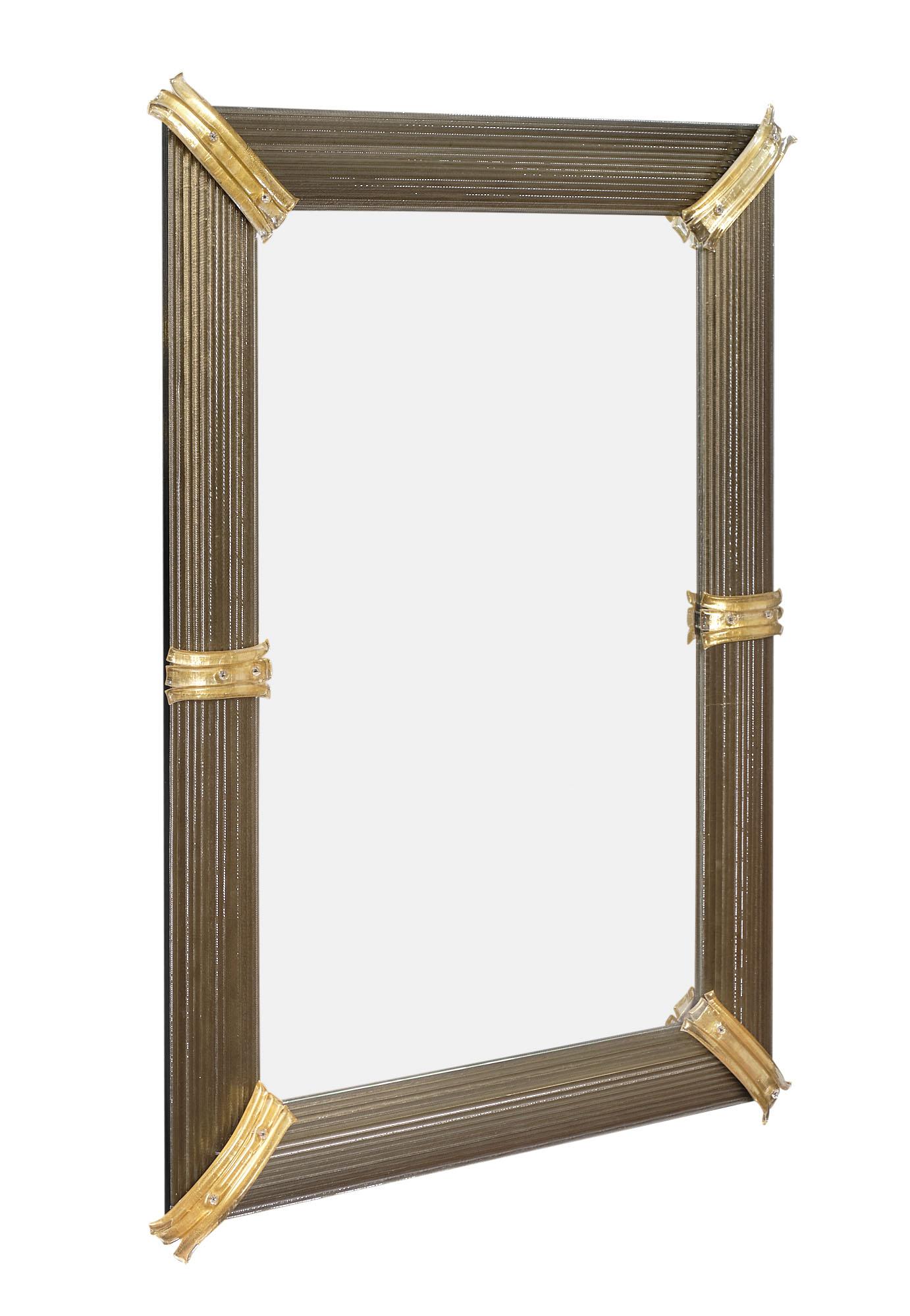 Mirror from Murano, Italy featuring multiple gray glass rods tied together to form a frame. Each corner is enhanced with a 24 carat gold fused piece of glass with texture.

This piece is currently a special order from Italy, please reach out for a