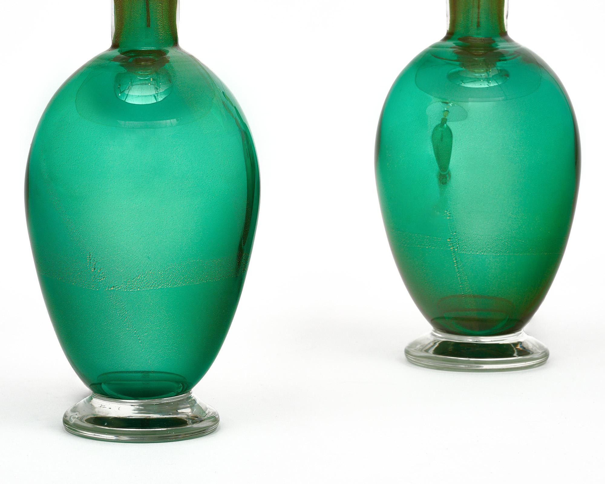 A pair of Italian hand-blown Murano glass mirrored avventurina lamps that contain 23 carat gold flecks and beautiful green glass. The process of fusing the gold flecks within the glass was aptly named as it means “adventure”, a charming way of