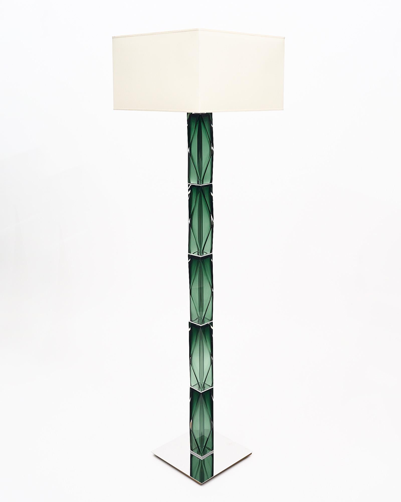 Pair of floor lamps made with green Murano glass elements on a chrome structure. Each hand-blown glass element has a jewel like shape with faceted angles. We love the way the light plays off the geometric glass of this pair. Each lamp has two bulbs;