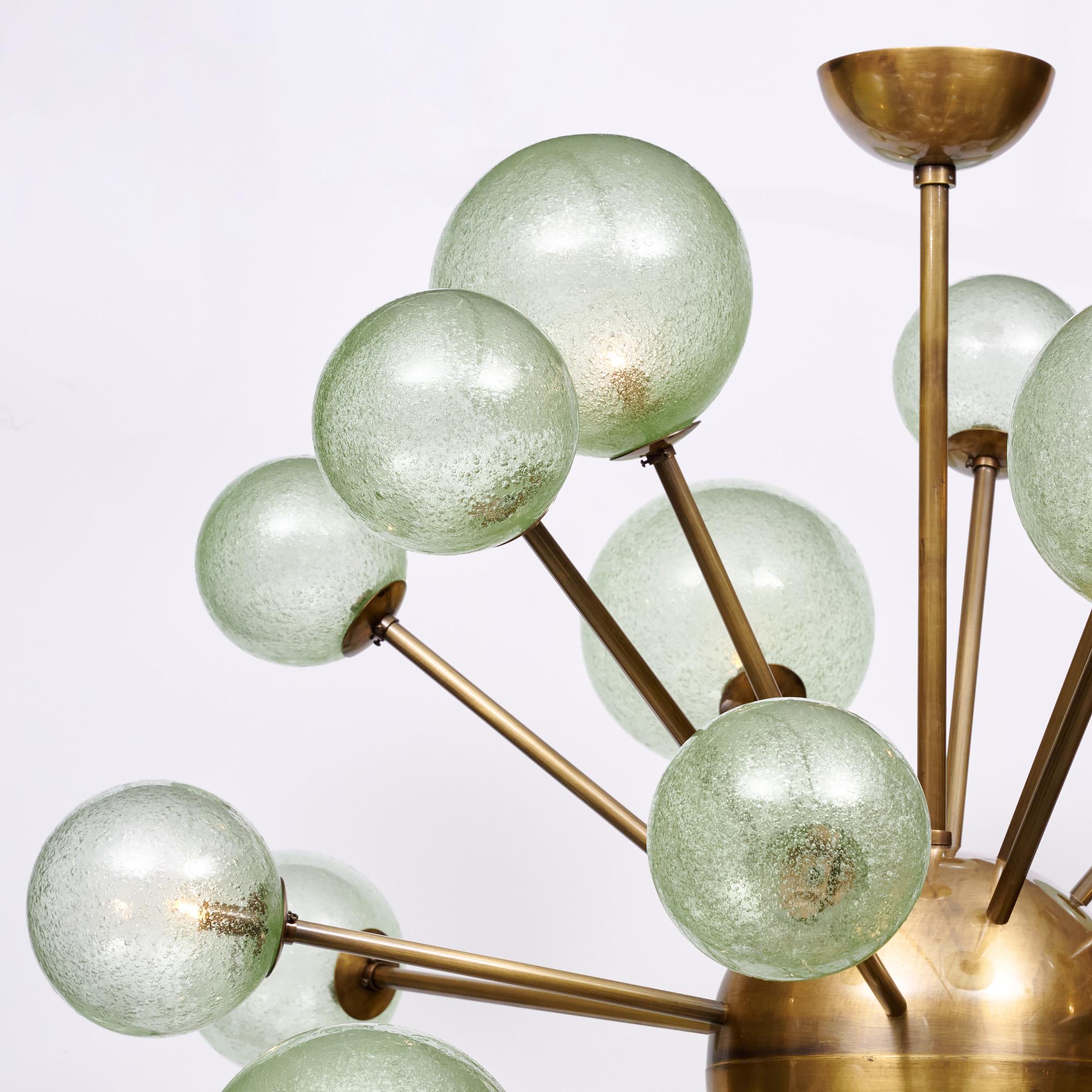 Chandelier from Murano outside of Venice, Italy. This fixture has a brass structure with emanating arms holding hand-blown green glass globes. Each globe has a beautiful; bubbled texture and a light green tone. This fixture has been newly wired to