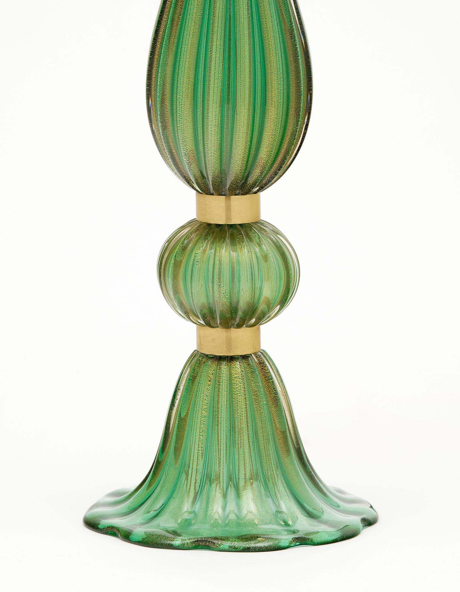 Pair of lamps from the island of Murano with ridged green glass blown and fused with 24 carat gold flecks in the “avventurina” technique. It is accented with gilt brass rings. They have been newly wired to fit US standards. Height to the top of the