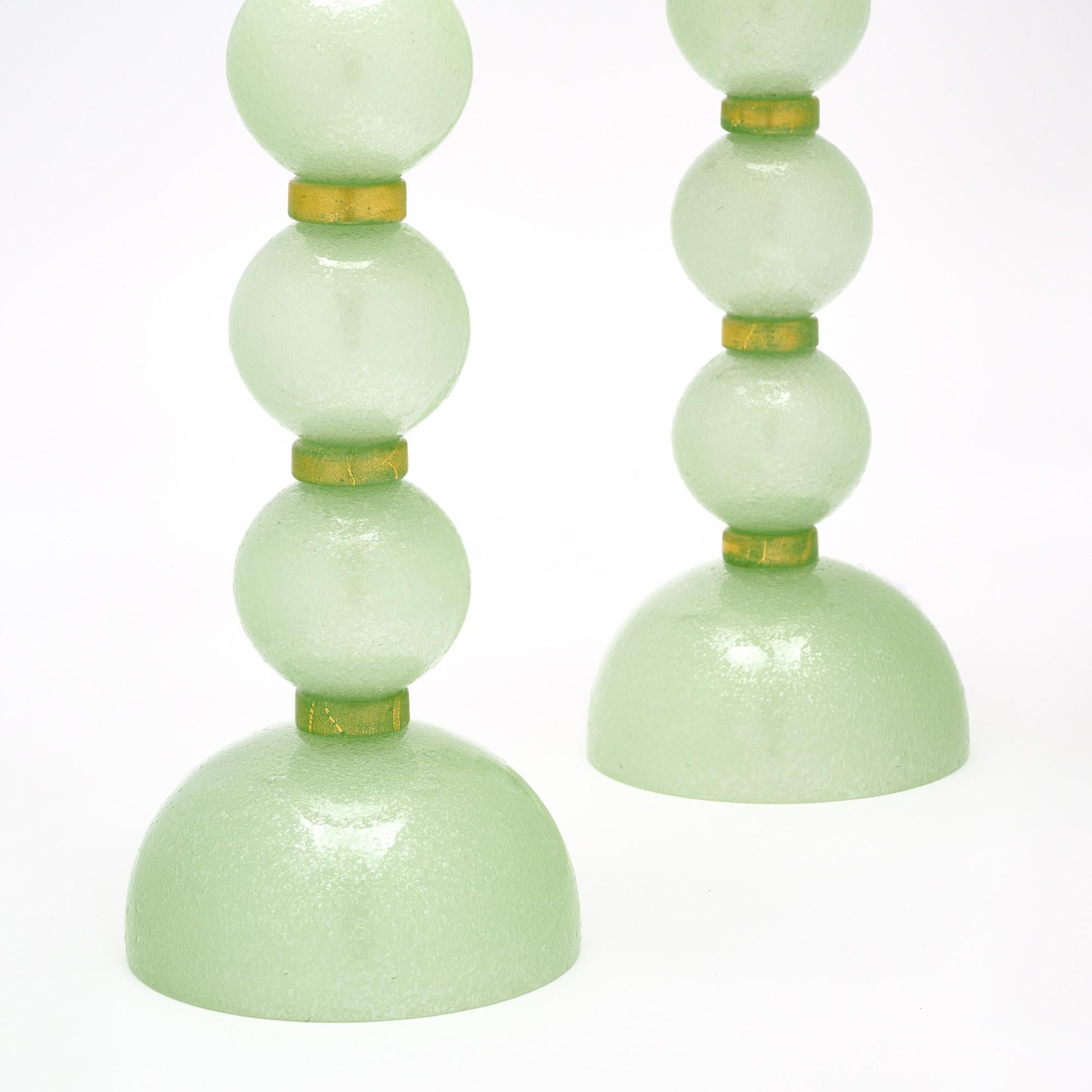 Pair of glass table lamps made of hand-blown glass from Murano, Italy outside of Venice. Each lamp features green glass globes made with the “pulegoso” technique which creates bubbles throughout the glass. They are alternating with “avventurina”