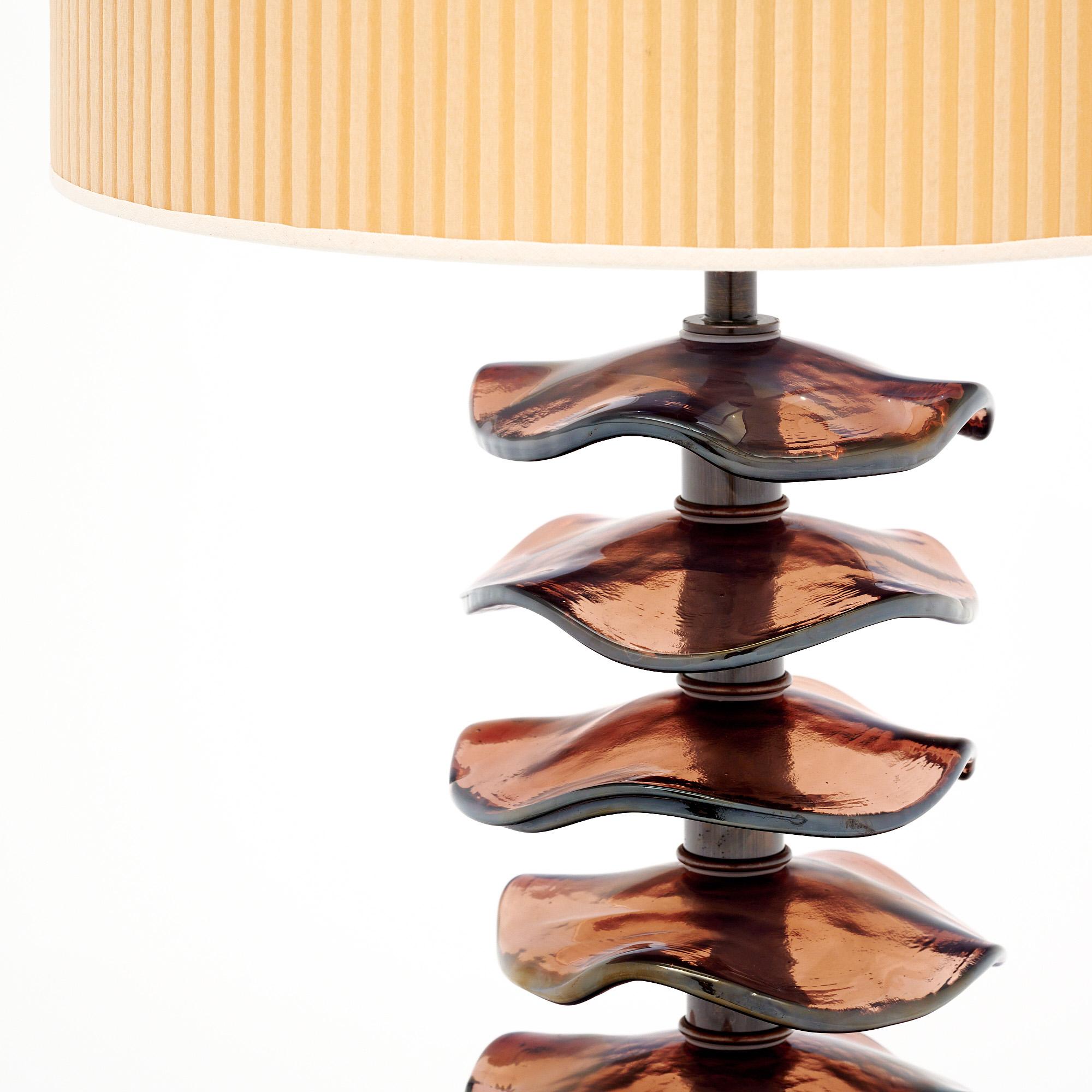 Pair of lamps from Murano, Italy outside of Venice. This pair boasts beautiful iridescent glass discs in a burgundy color along a brass stem. They have a brass base. The brass is finished with a bronze tone. They are hand-crafted and have been newly