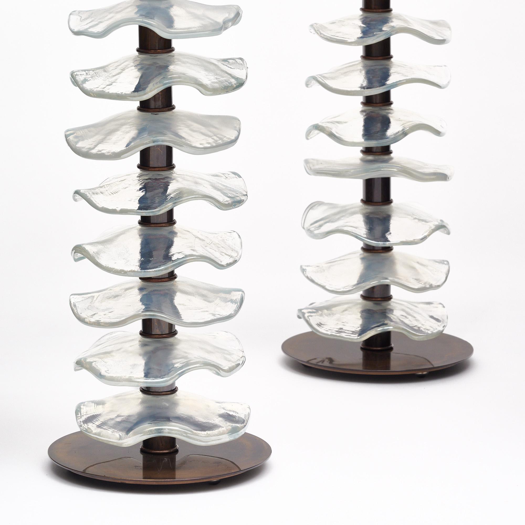 Paire de lampes d'Italie en verre de Murano. Cette paire présente de magnifiques disques en verre irisé le long d'une tige en laiton. Ils ont une base en laiton. La finition du laiton est de couleur bronze. Ils sont fabriqués à la main et ont été