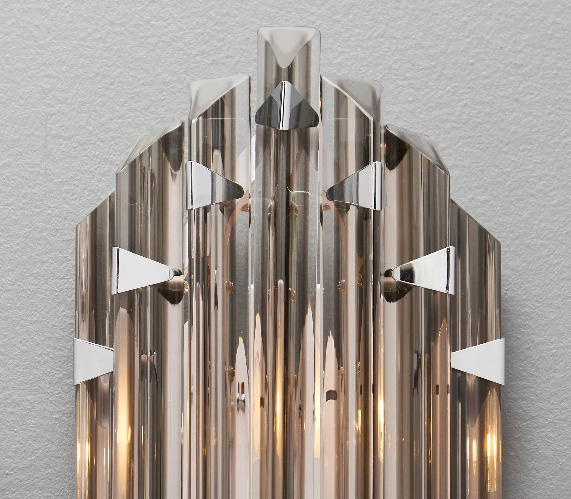 Italian Murano glass smoked Venini sconces. This “triedi” style pair by Venini features chromed attachments and structure. A smoked strip of glass is fused into the clear crystal glass, providing the right hint of color. This pair has been newly