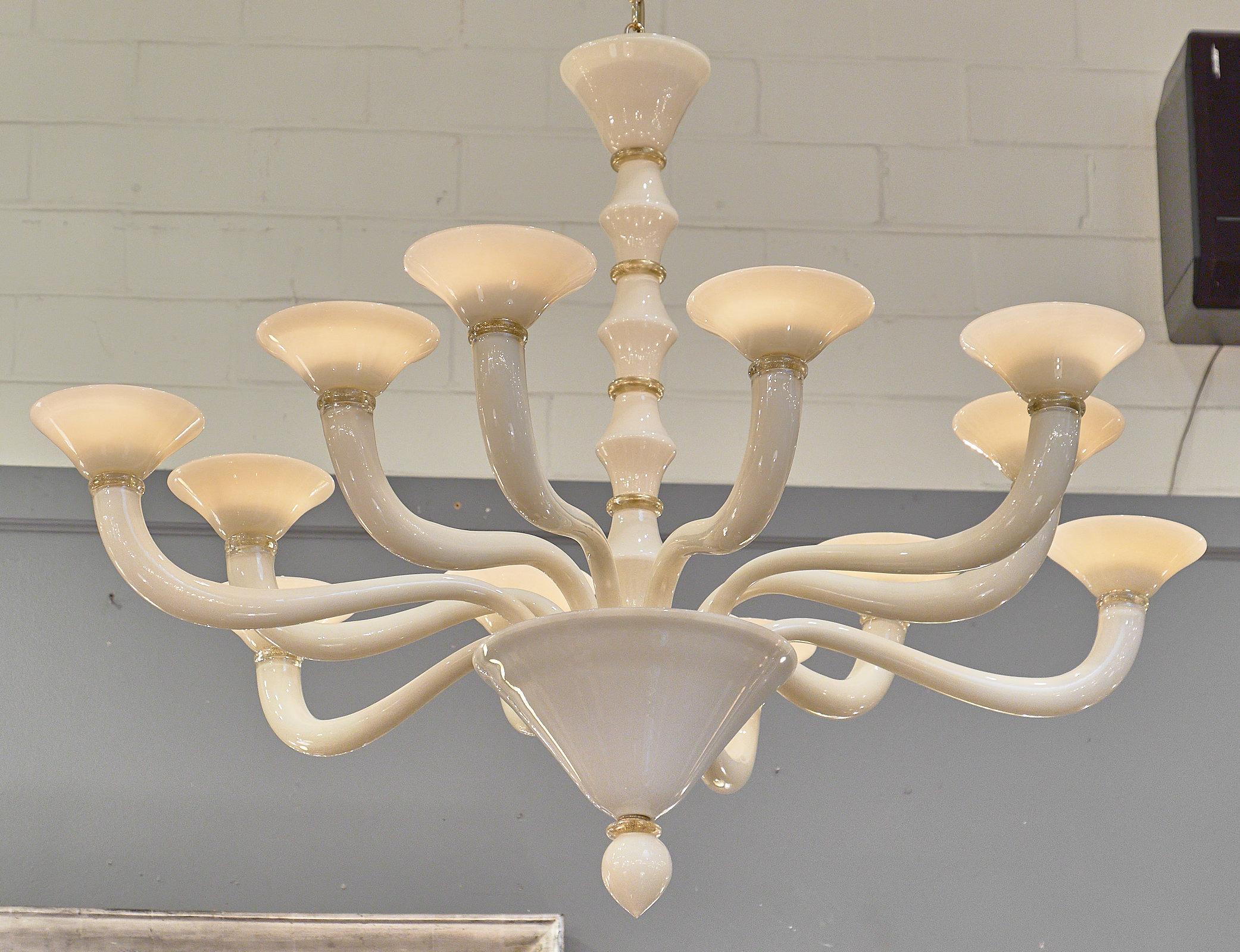 Unique chandelier made of Murano glass in a beautiful, striking ivory color. The twelve arms of the chandelier alternate in length for a dynamic depth. To add texture, there are rings of Murano glass with 23-karat gold leaf throughout the fixture.