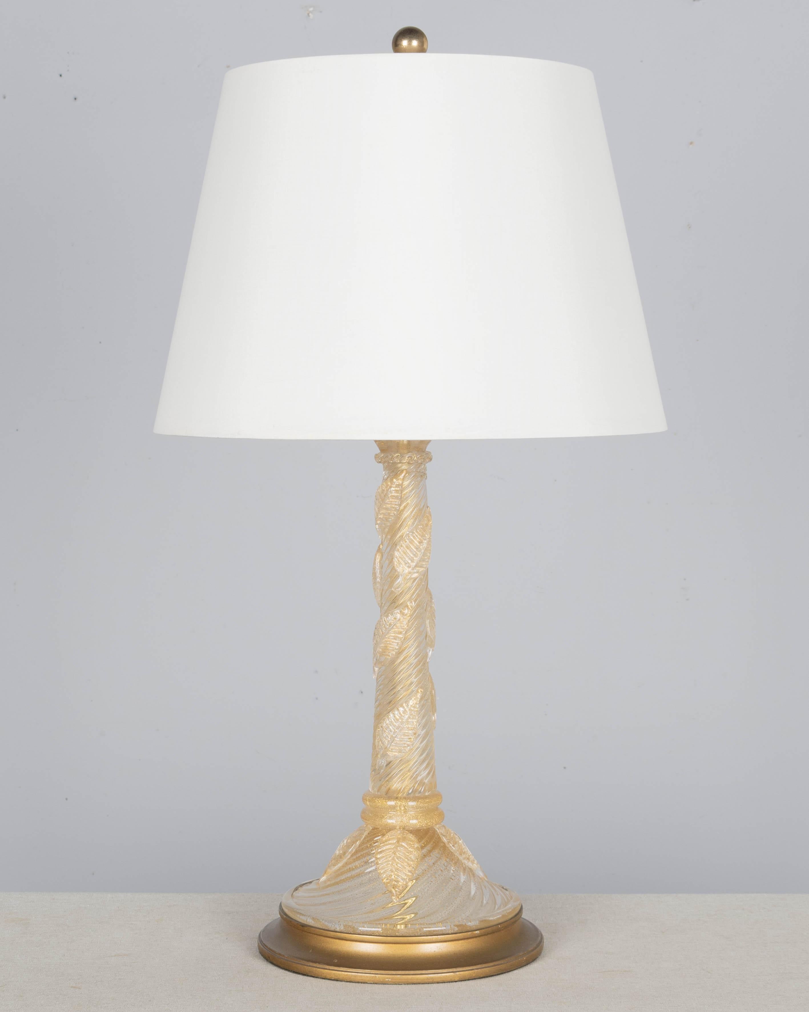Lámpara de cristal de Murano de mediados de siglo, de Barovier & Toso. Cristal transparente soplado a mano con inclusiones de pan de oro auténtico. En dos partes: un tallo arremolinado y una base circular, decorada con hojas de cristal aplicadas.