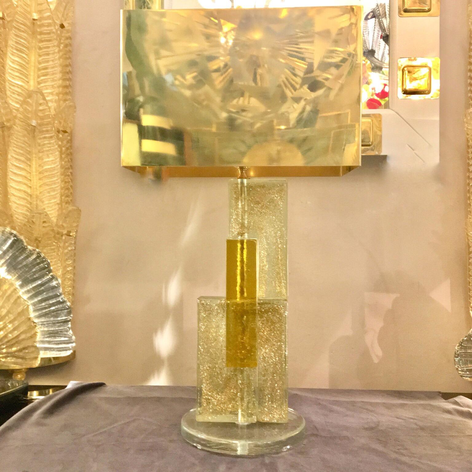 Handcrafted Murano glass table lamp, yellow glass and clear glass infused with gold flecks, rectangular brass lampshade. Round clear glass base. One bulb.