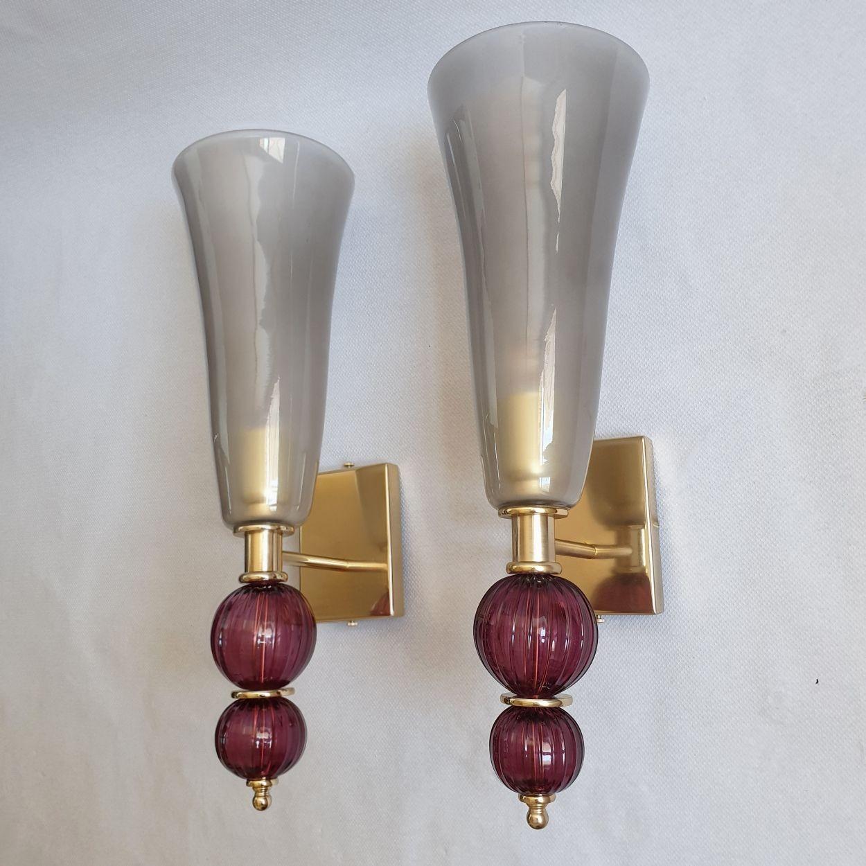 Pair of tall Mid Century Modern Murano glass sconces, attributed to Vistosi, Italy 1980s.
The pair of sconces is made of a tall urn shaped top vase in a light gray color, nesting the light.
The glass is translucent, creating a warm glow of light,