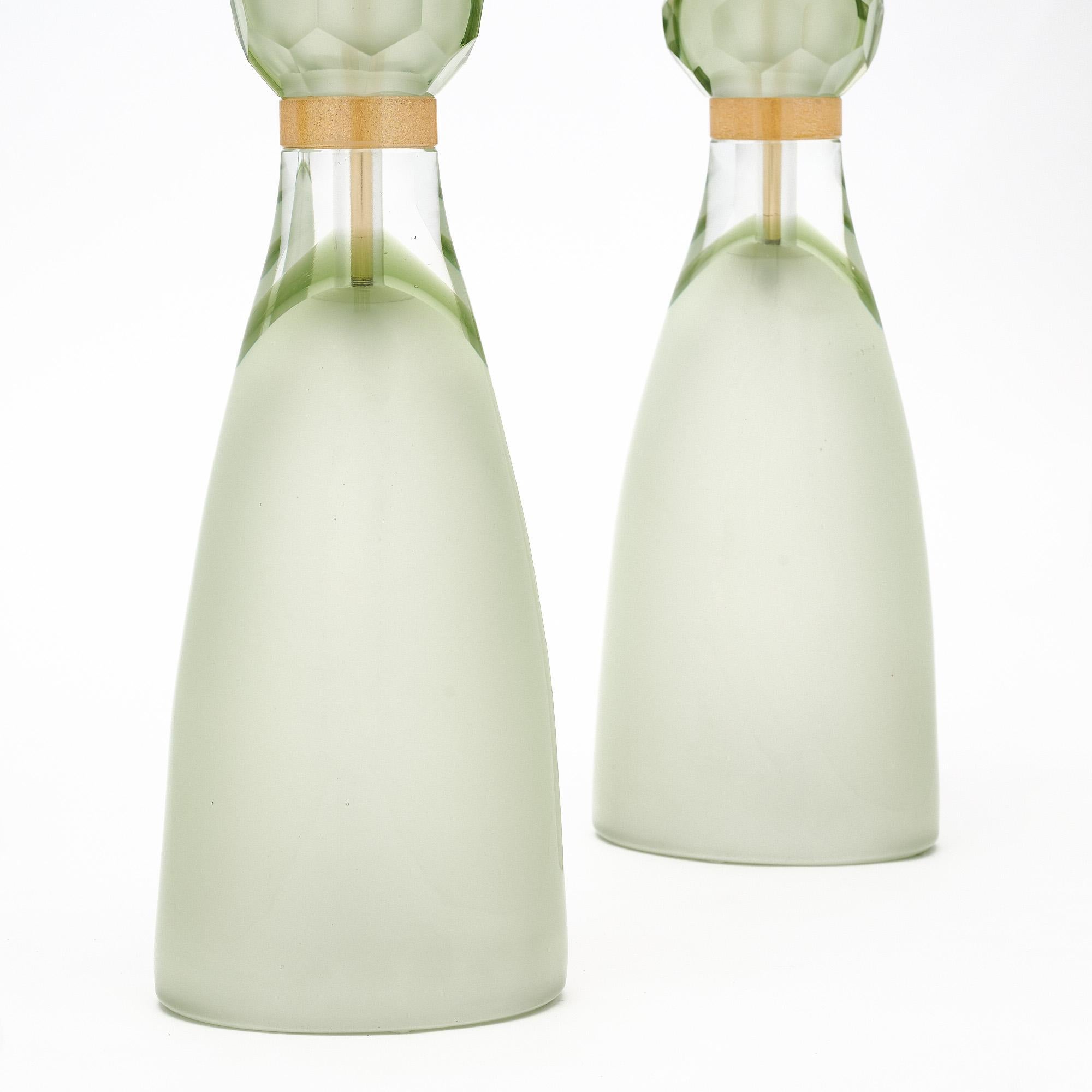Italian hand-blown Murano glass table lamps in a polished light green glass fading to clear just below 23-carat gold flecked rings. At once formal and nonchalant, these sleek lights are sure to take your space to the next level. We were drawn to the