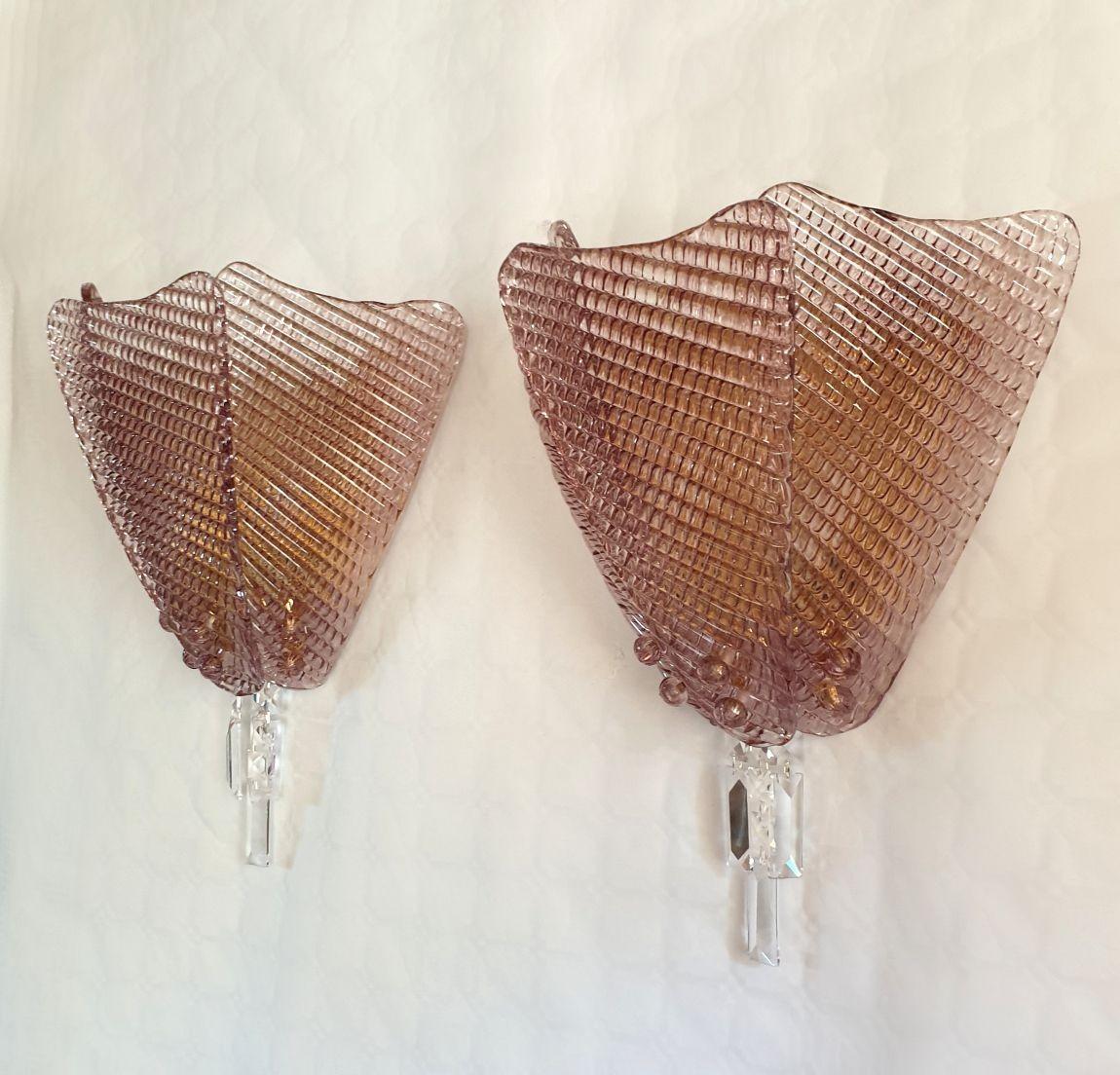 Pair of large Murano glass wall sconces, Mid-Century Modern, Italy 1980s.
The sconces are attributed to Vistosi.
The sconces are made of 3 stylized light purple leaves, brass finish mounts and decorative crystals.
The Murano glass is translucent,