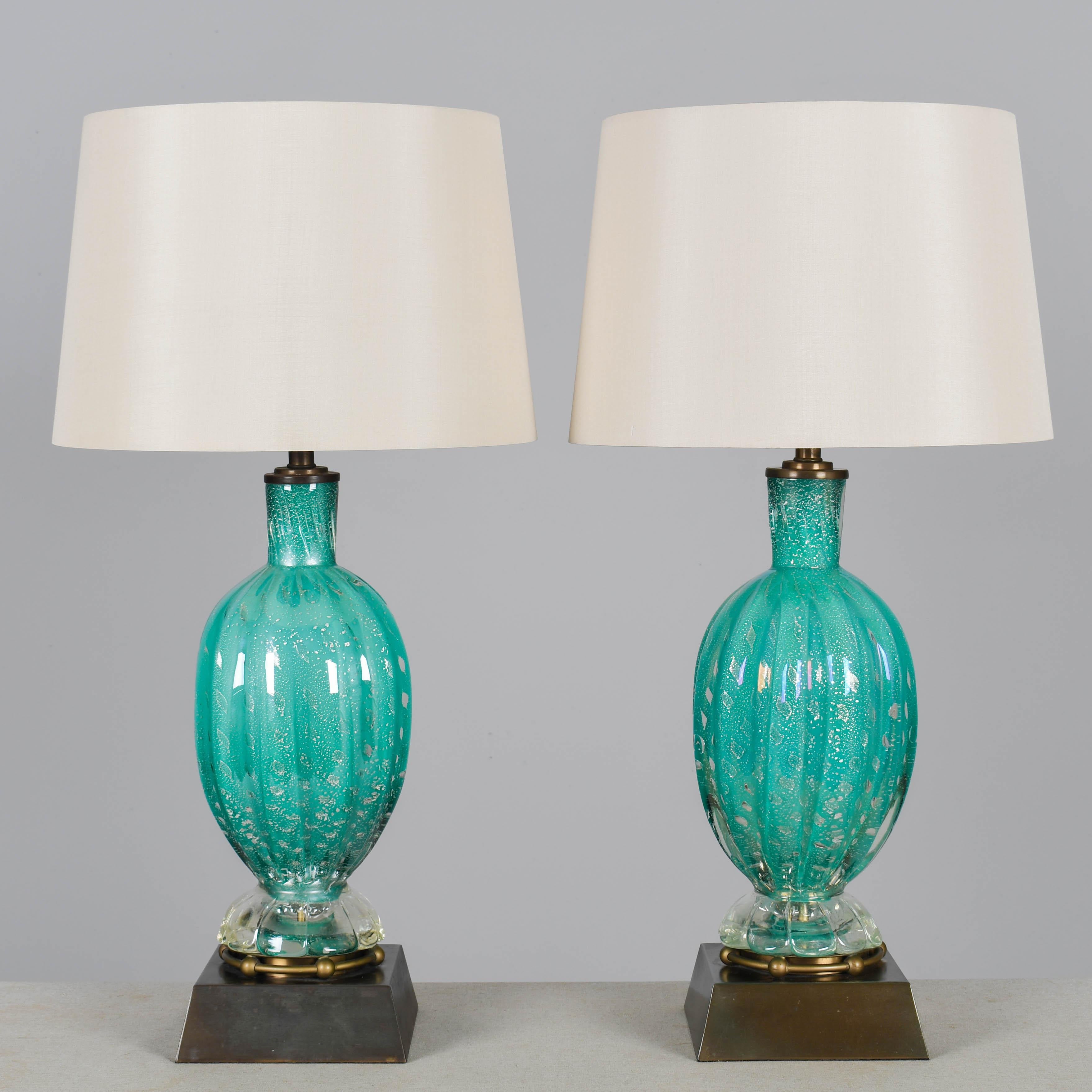 Paire de lampes en verre de Murano du milieu du siècle par Barovier&Toso. Belle couleur sarcelle avec des bulles contrôlées et des inclusions argentées. Base et quincaillerie en laiton d'origine. Belle patine d'ancienneté de couleur bronze avec des