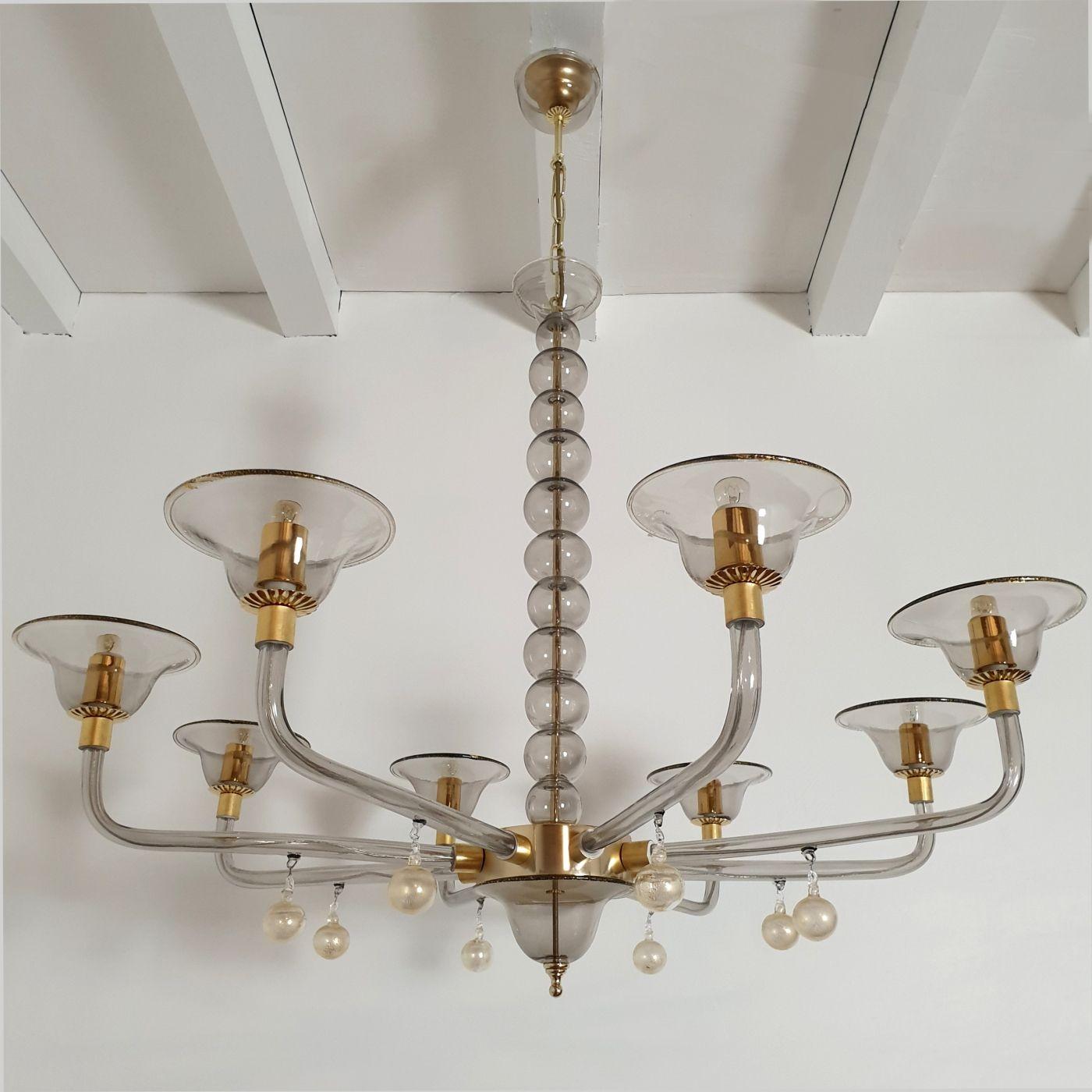 Large hand blown murano light gray / beige transparent glass chandelier.
Attributed to Venini, Italy. Mid-Century Modern lighting. 1970s. The chandelier is made of colors Murano glass, with some gold leaf accents. It has eight arms / lights The
