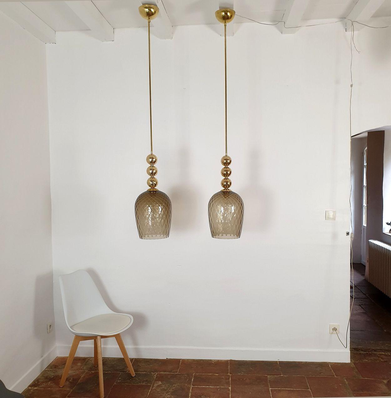 Pair of large Mid-Century Modern pendant lights, attributed to Mila Schon, Italy 1970s.
Sold by pair.
The pendants are made of brass and a transparent brown Murano glass shade.
The height of the brass stem can be adjusted.
The brass canopy is 5.51