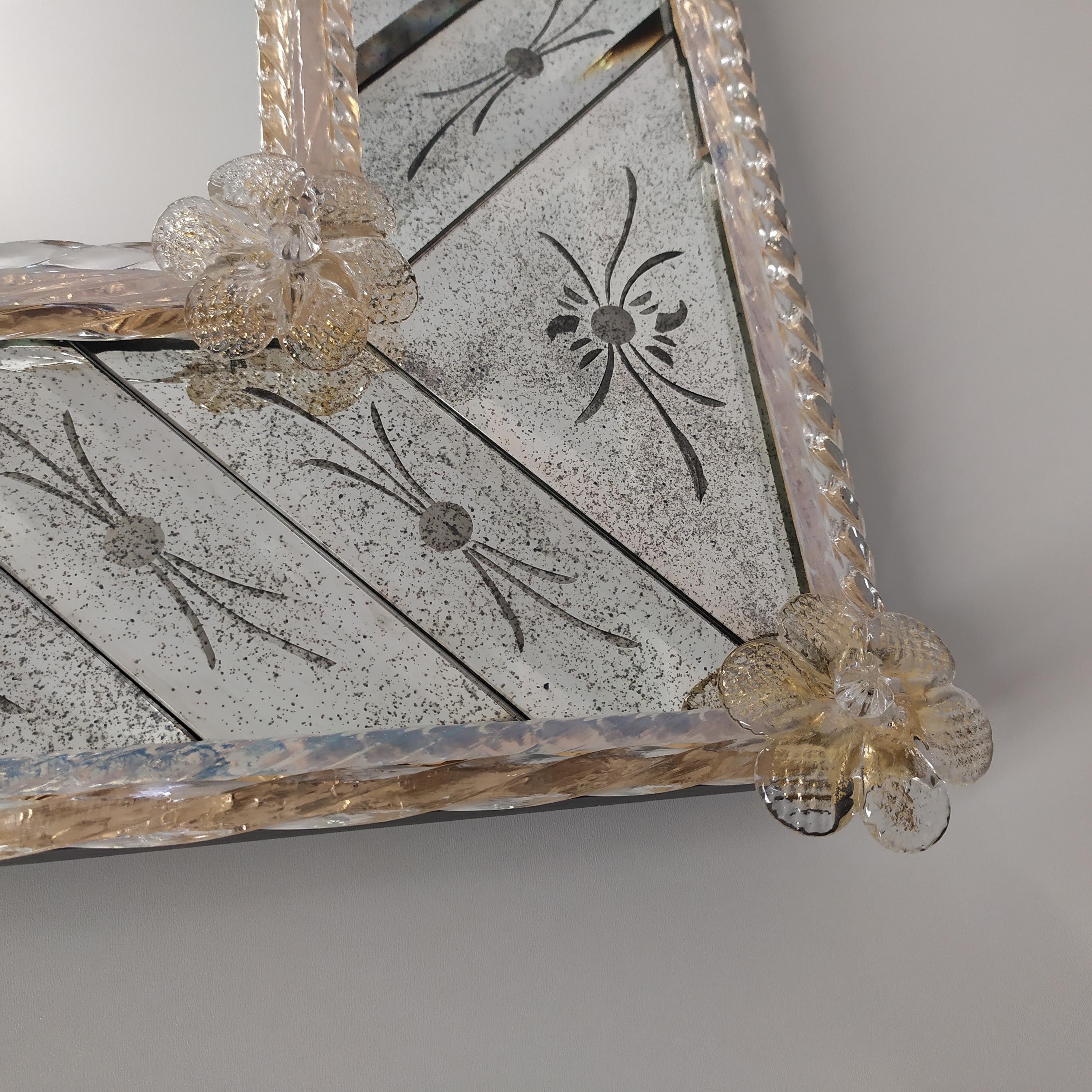 Rectangular Murano glass mirror in Venetian-style, made by the expert hands of the Masters of Murano, with a frame composed of beveled and hand-engraved pieces on an antiqued mirror, with finishing of crystal reeds on a golden background and gold