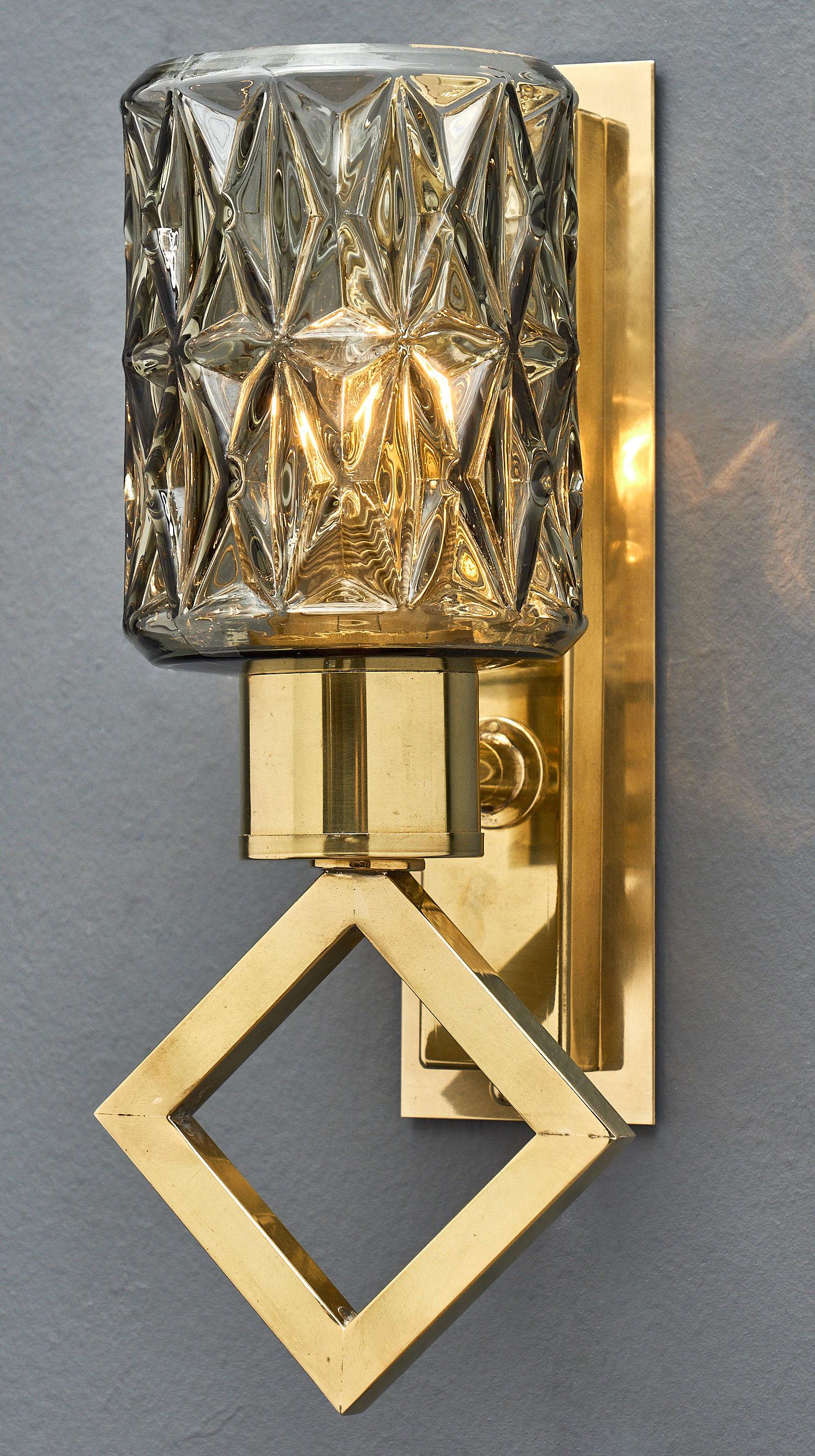 A pair of modernist diamond Murano glass sconces with gilt brass structures. We loved the geometric elements of the structure combined with the diamond patterns in the glass. This pair has been newly wired to fit US standards.

This pair is