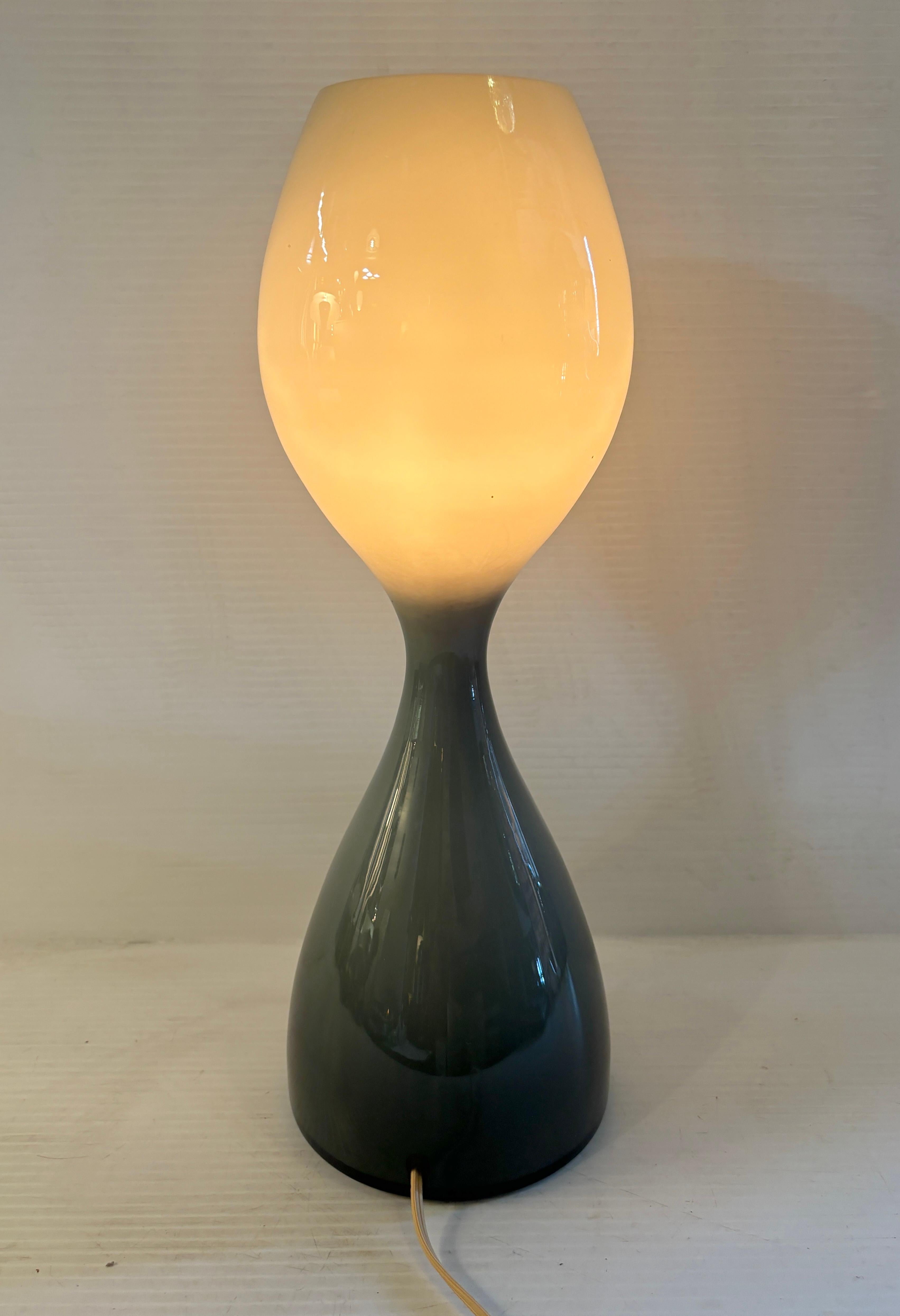 Vintage hourglass shape table lamp in blown glass with teal blue/grey coloring. Single bulb set inside the glass gives a nice glowing light.
Please confirm location NY or NJ