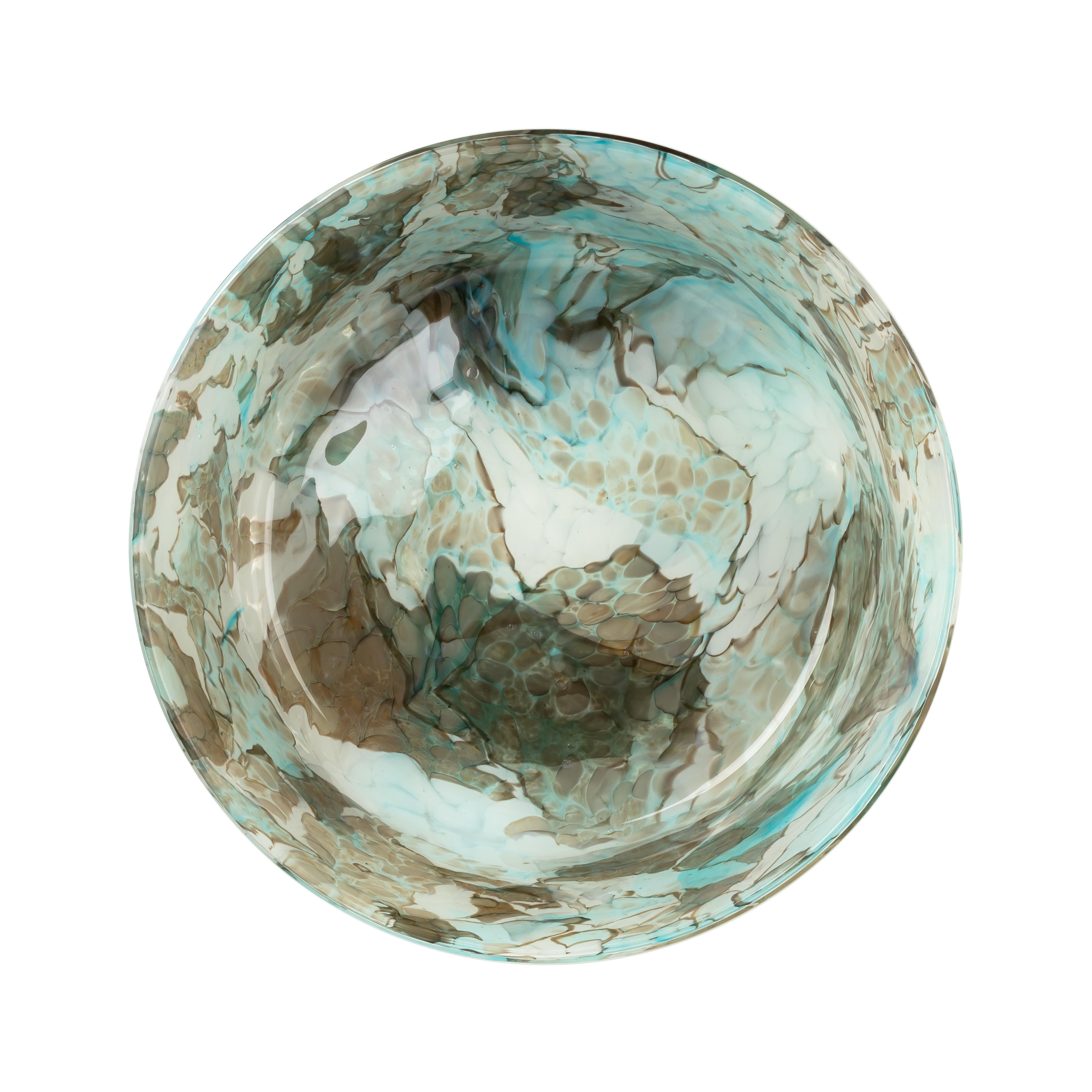 Stories of Italy glass bowl is meticulously crafted by skilled artisans in Venice. Its stunning aquamarine color effortlessly enchants the eyes, bringing a touch of sophistication to any space. Each bowl is meticulously formed using the ancient