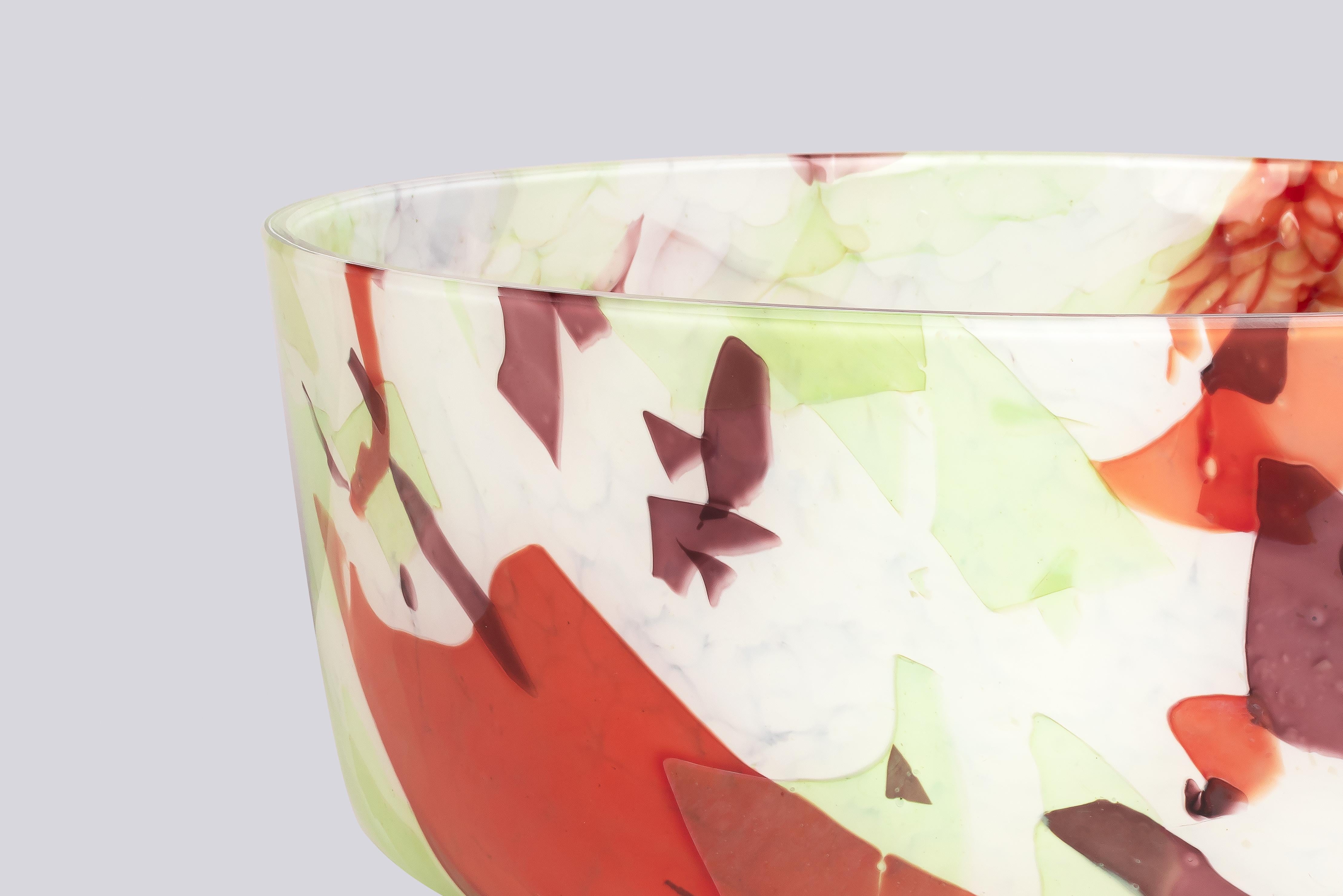 Crafted by skilled artisans from Murano, Italy, this exquisite vessel showcases a blossoming fusion of spring's colors. Green, amethyst, and red hues are delicately arranged on an ivory base, embodying impeccable craftsmanship. Each element captures