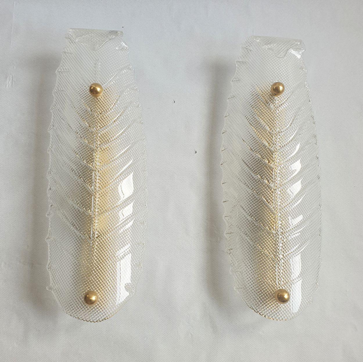 Pair of large Mid Century Modern Murano glass sconces, attributed to Vistosi, Italy 1970s.
The vintage sconces have a stylized leaf shape, in a hand blown textured clear Murano glass.
The Italian sconces frame is in brass.
The sconces back plate